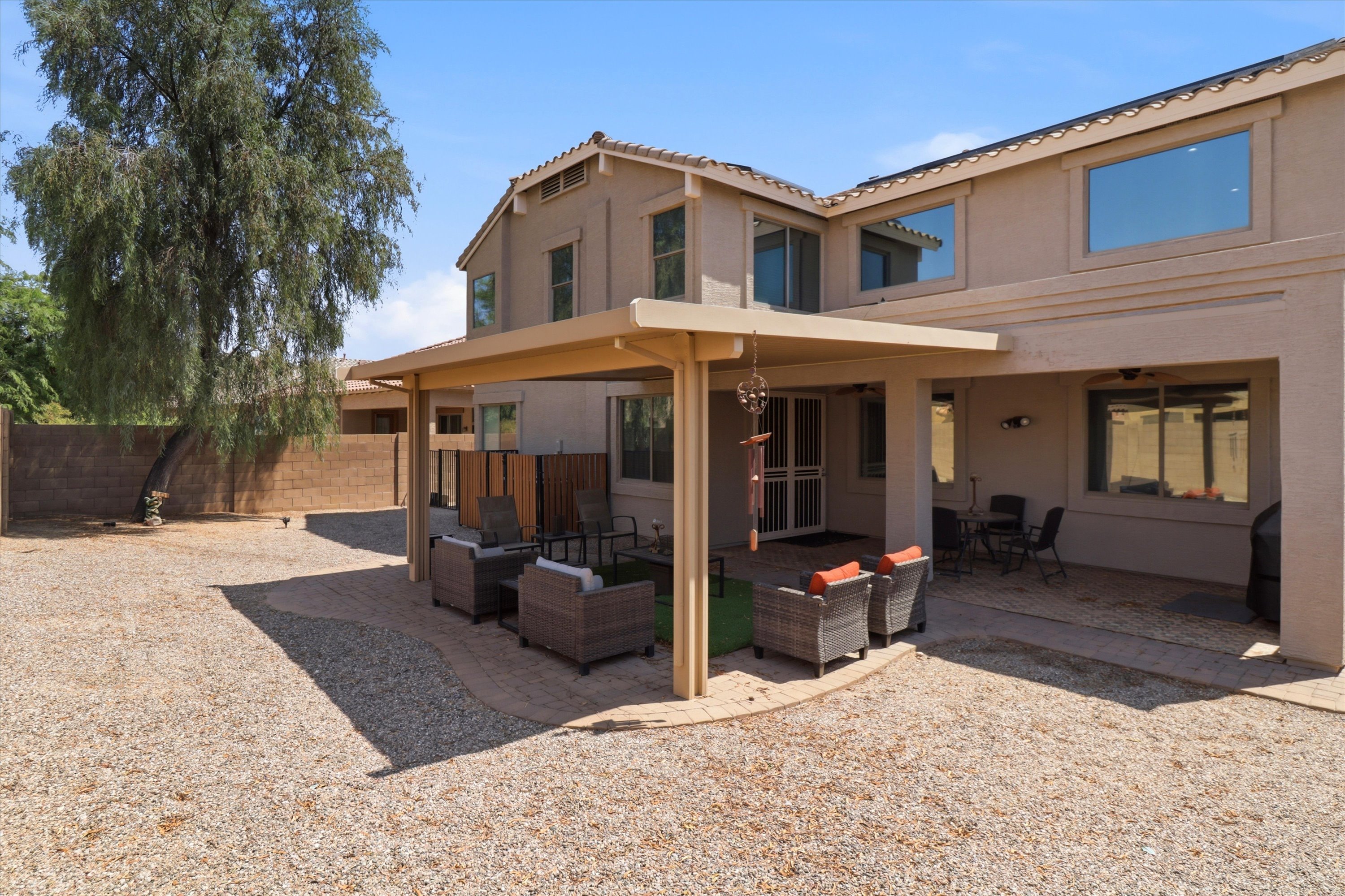 Backyard with a covered patio, outdoor seating, and a large open yard for fresh air.