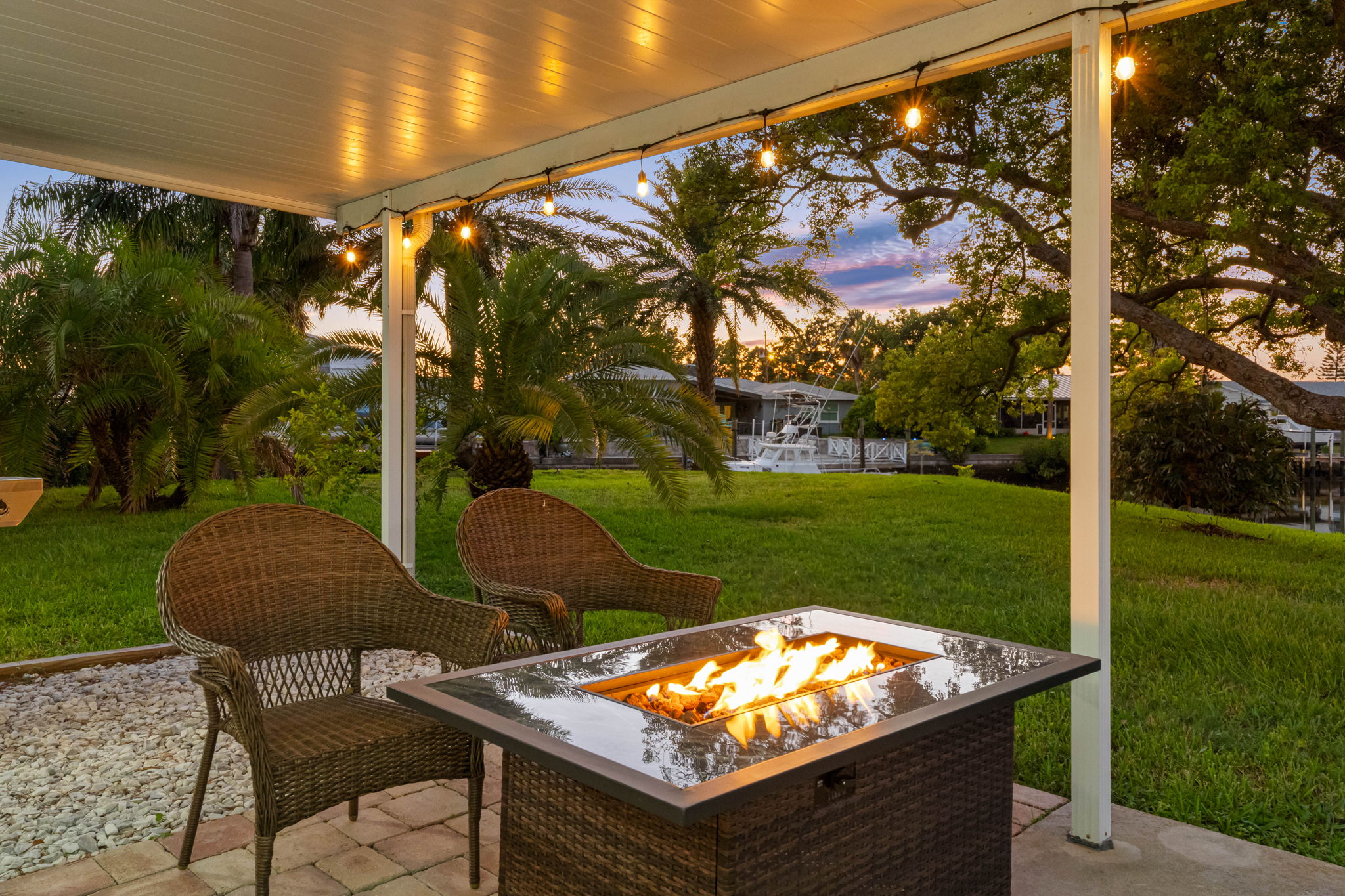 A modern fire pit anchors the seating area, offering warmth and a focal point for evening conversations under the stars.