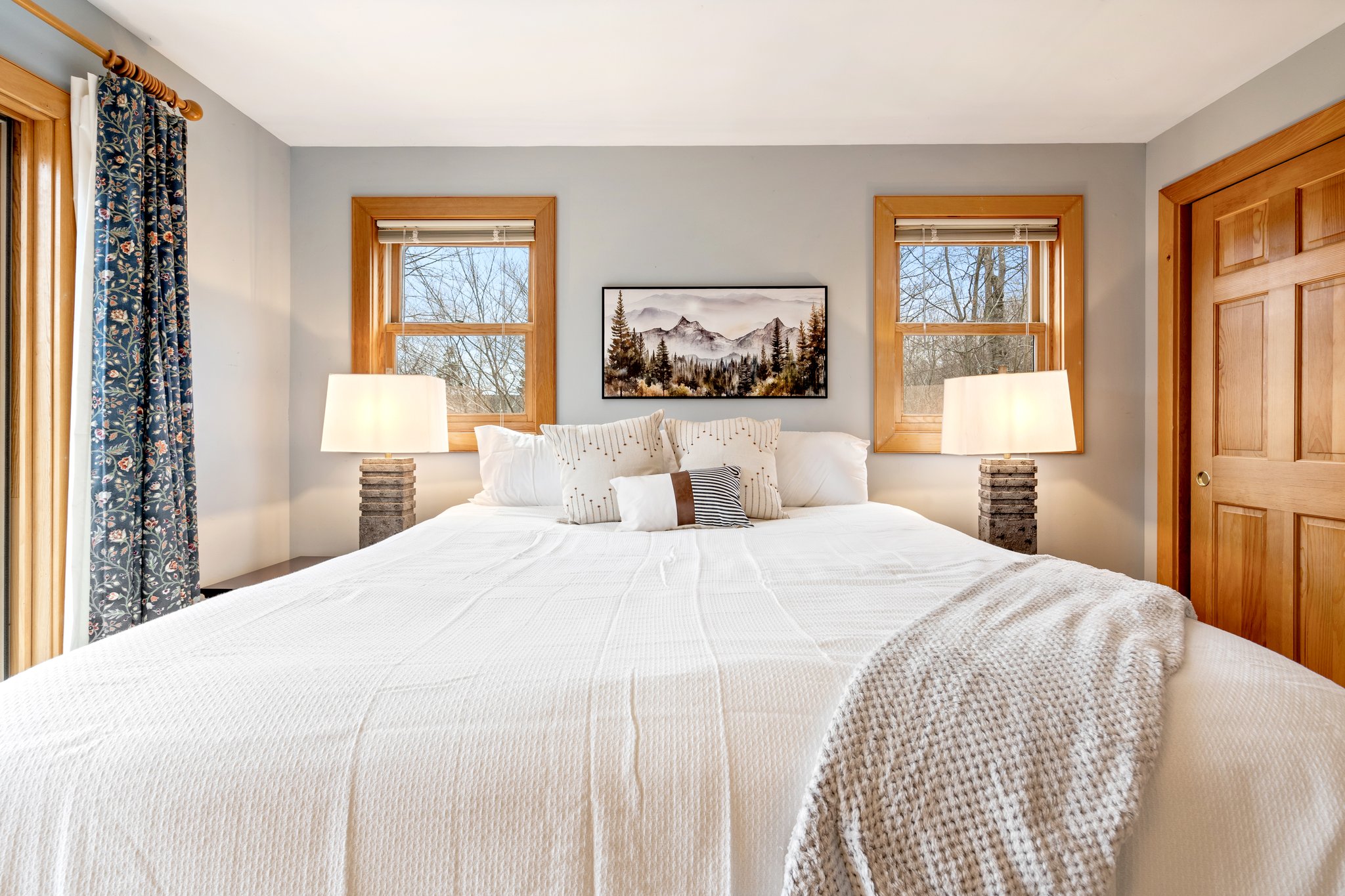 Wake up to natural light and mountain views in this serene bedroom retreat, featuring a plush king bed and direct access to the deck.