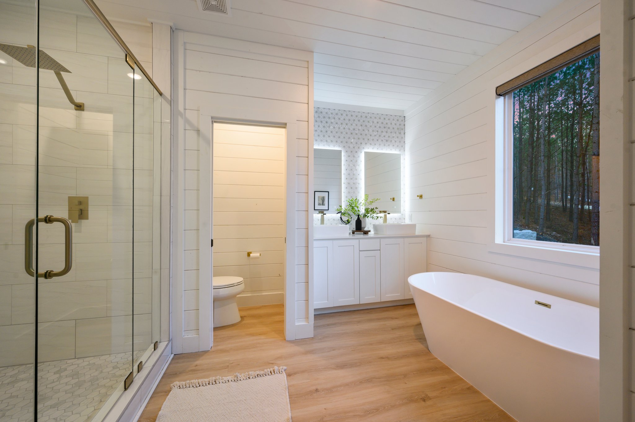 Crisp white shiplap walls and warm wood floors blend modern design with cabin charm.