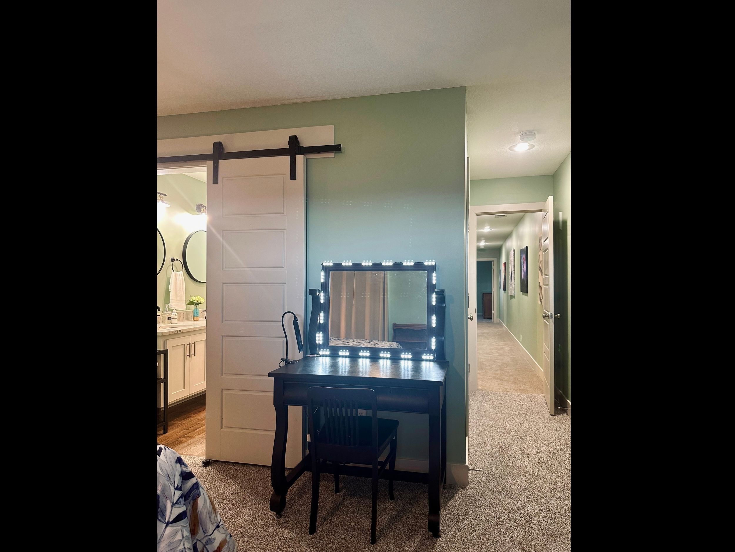 Primary suite desk illuminated with vanity lighting, ideal for morning routines or focused remote work.