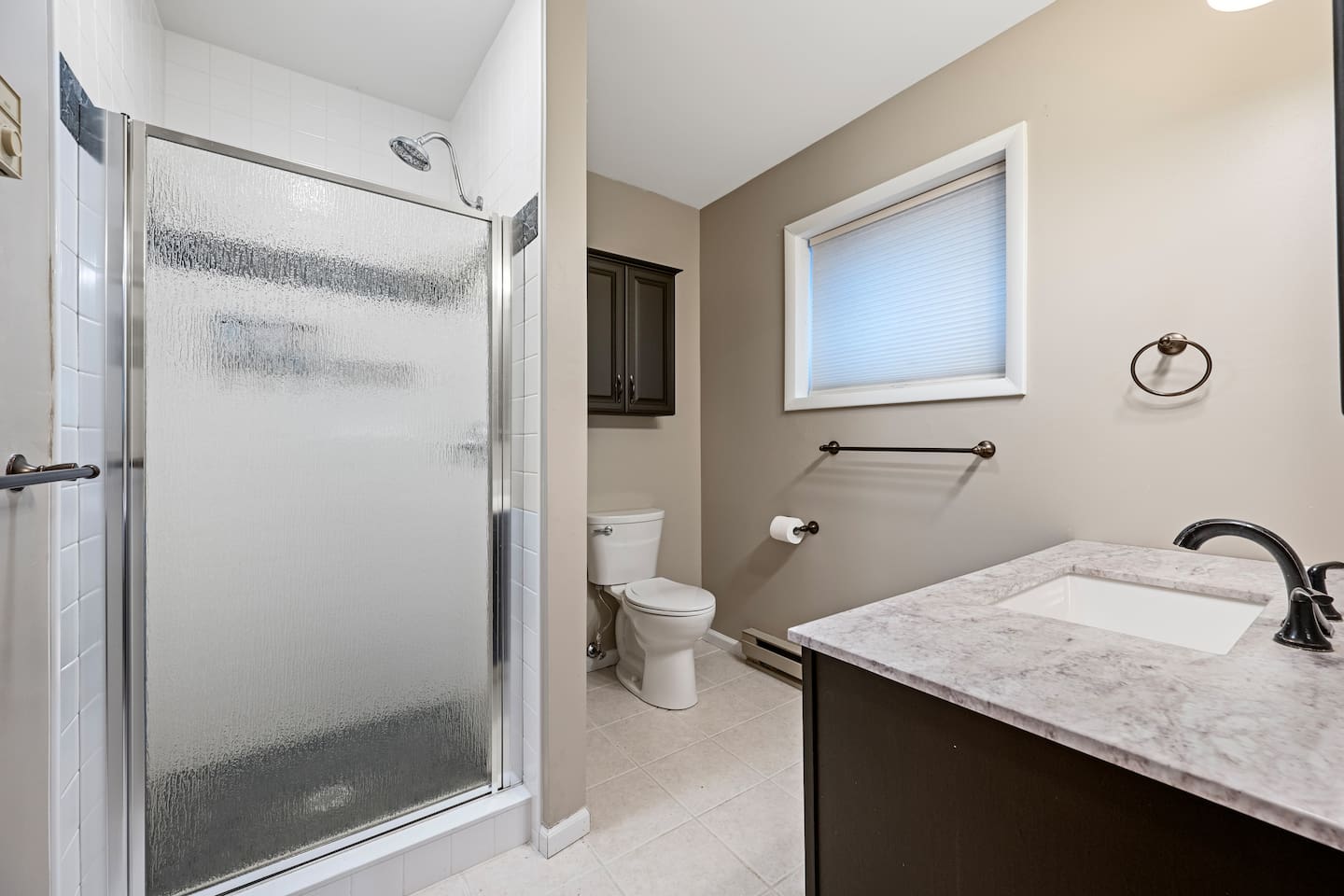 Full bathroom off of Bedroom 1.  The shower has a stone floor.