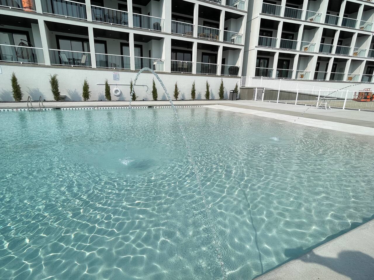 Pool 2 is located in front of Building 1 with a beach entry, adult tables in the deep end, and fountains.