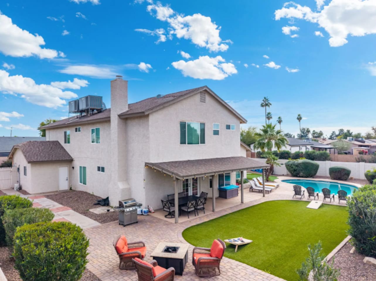 Backyard oasis with pool, covered patio, firepit, and manicured lawn—perfect for relaxation and gatherings.