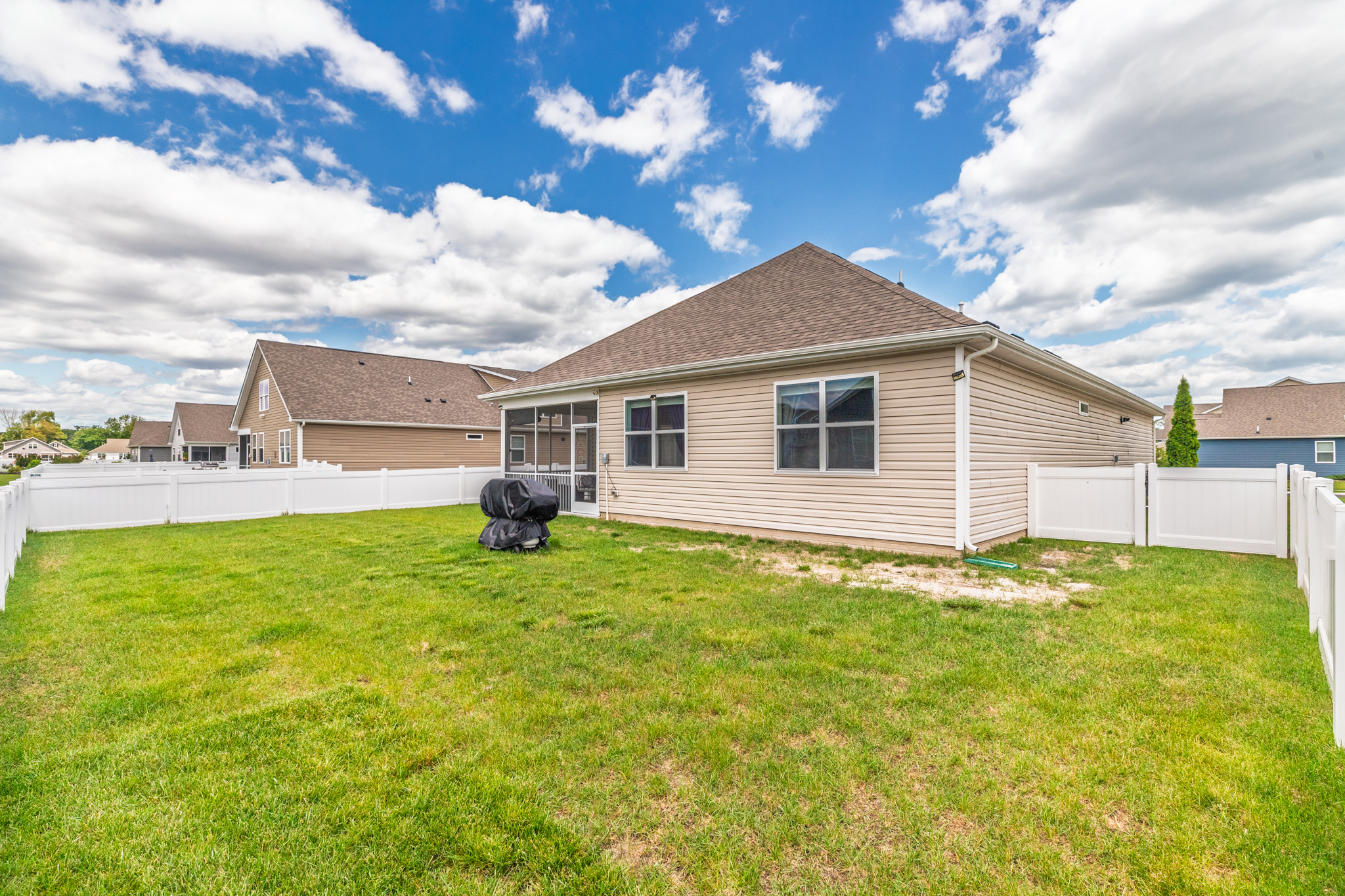 This perspective highlights the depth of the yard and its seamless flow from indoor living to outdoor play—perfect for family gatherings and group barbecues.