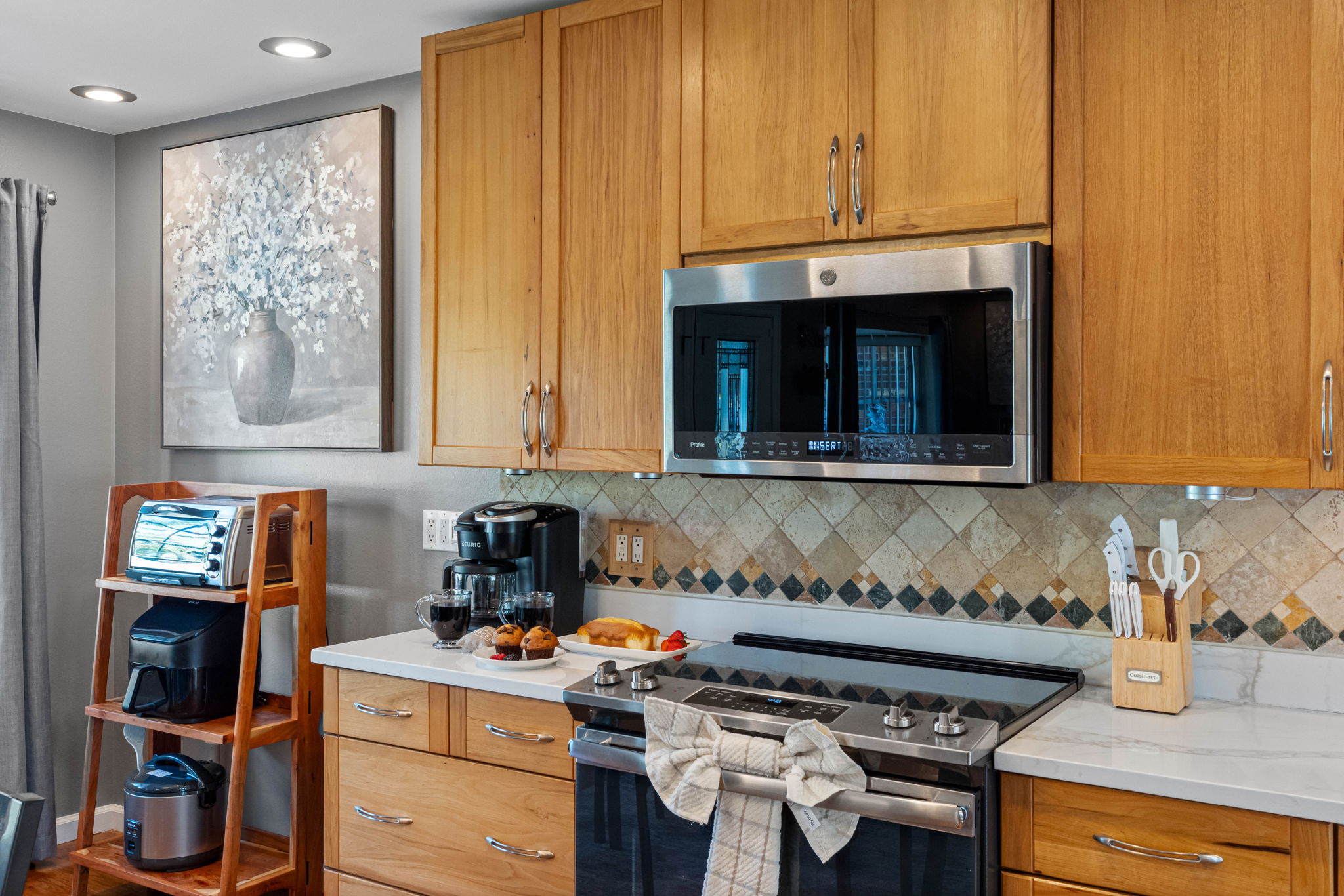 The tile backsplash with diamond accents adds a timeless detail, perfectly complementing the sleek modern finishes throughout the kitchen.