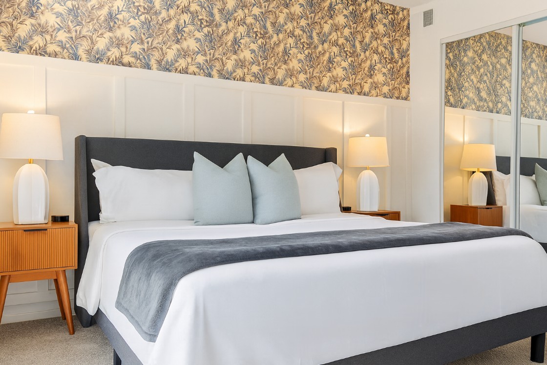 Primary bedroom with king bed, nightstands, lamps, and vibrant wall art for a welcoming retreat.