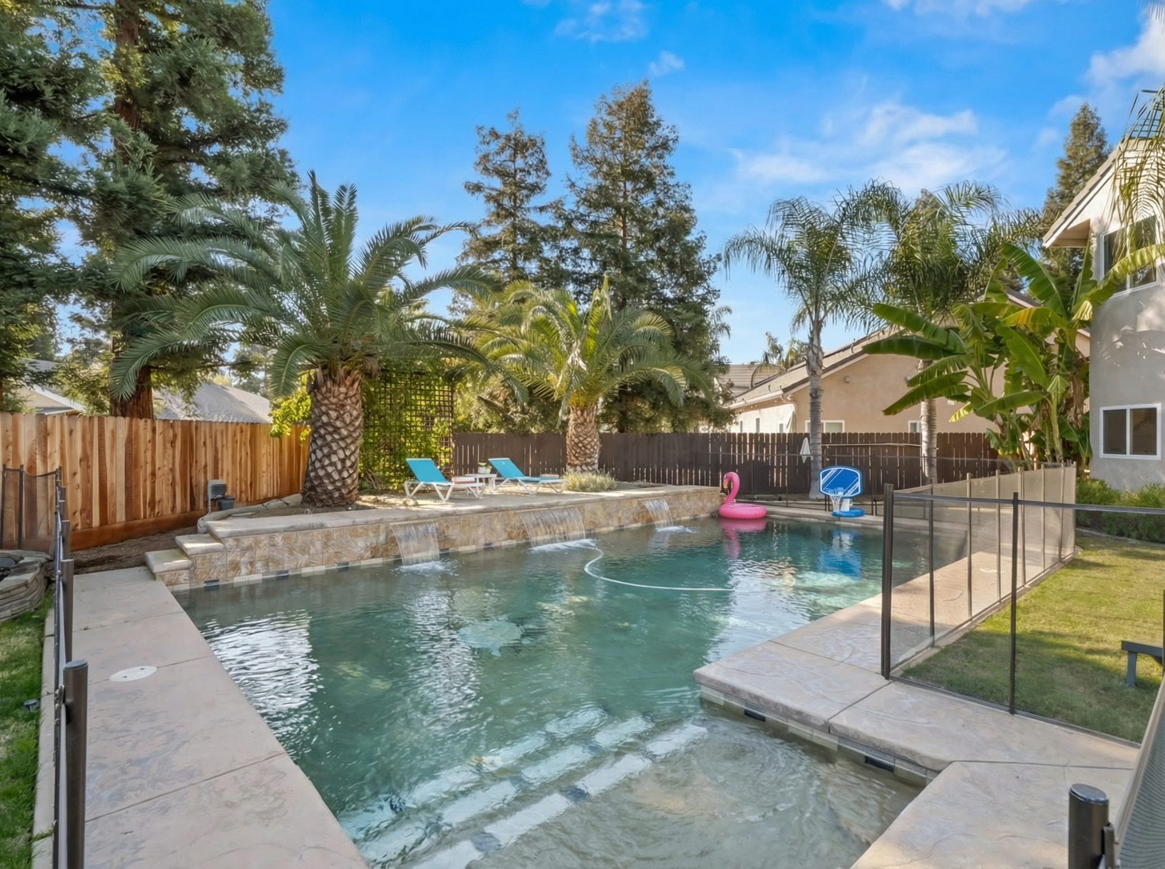 Pool floats, splash features, and nearby lawn space create all-day entertainment for the whole family.