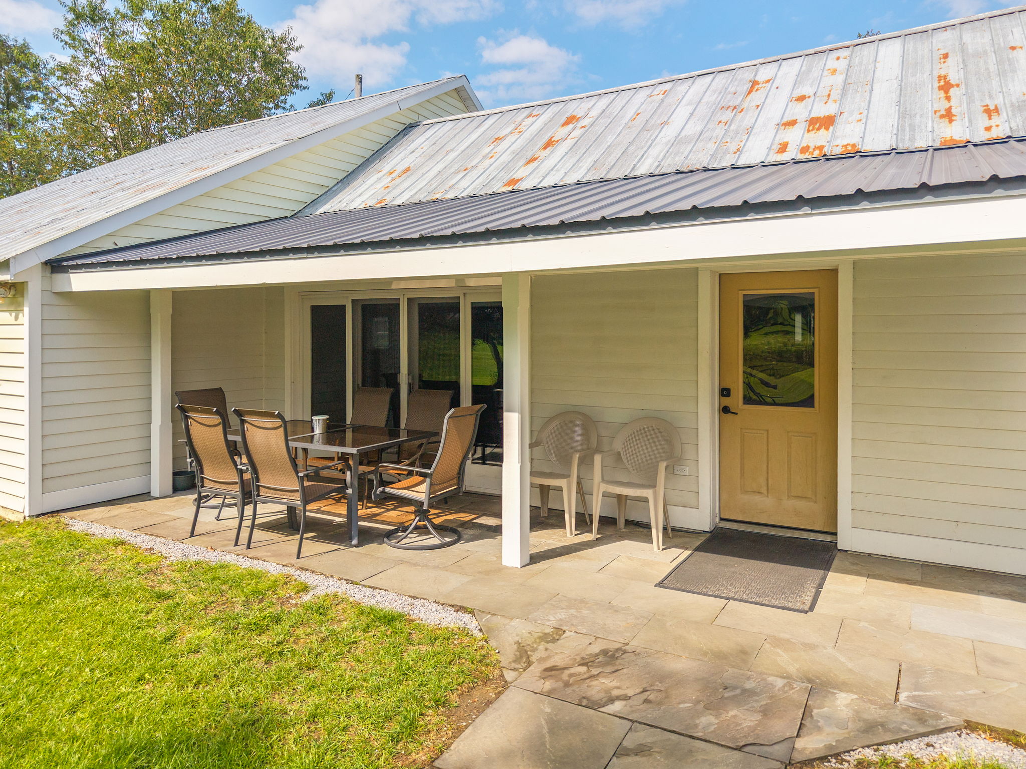 Sliding glass doors connect the indoor dining area to the covered patio.