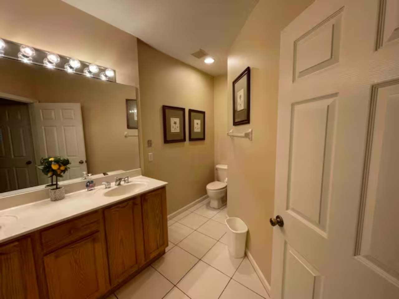 Spacious bathroom featuring a long vanity, tile flooring, and clean neutral finishes.
