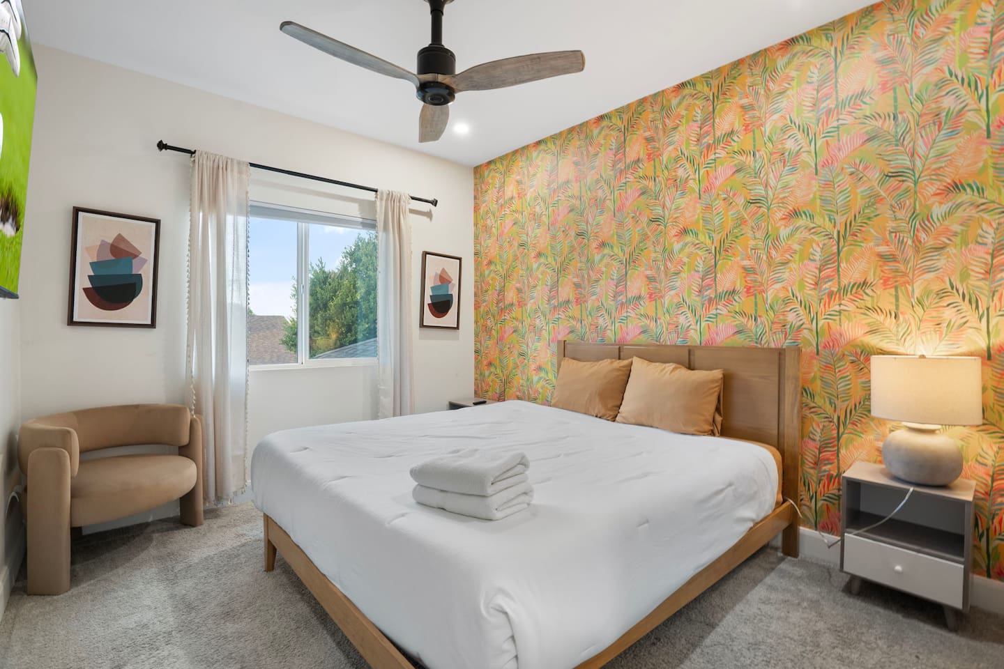 Cozy guest bedroom with bold tropical wallpaper.