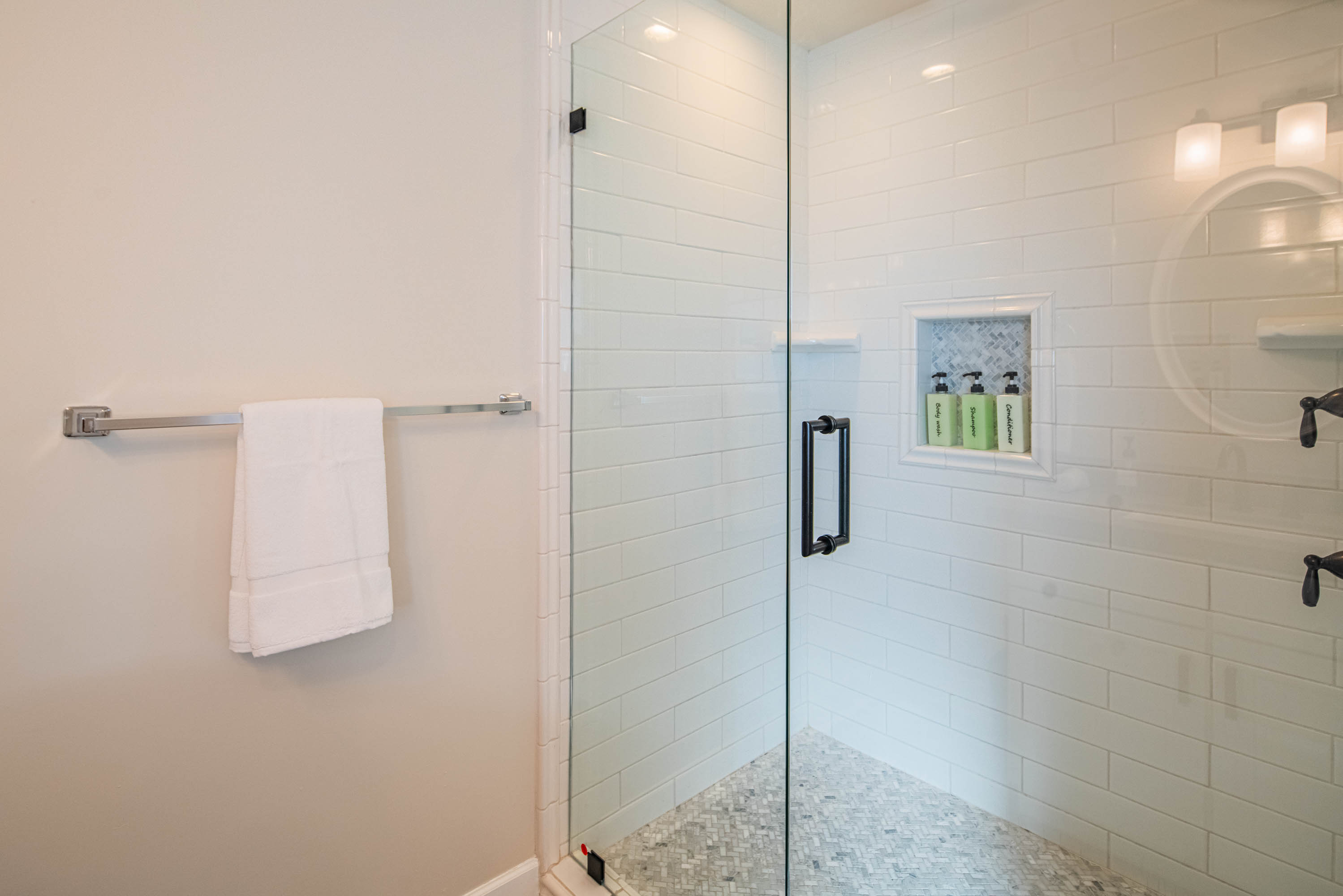 Clean, modern walk-in shower with glass enclosure and hotel-style amenities — designed for comfort and easy group use during your stay.