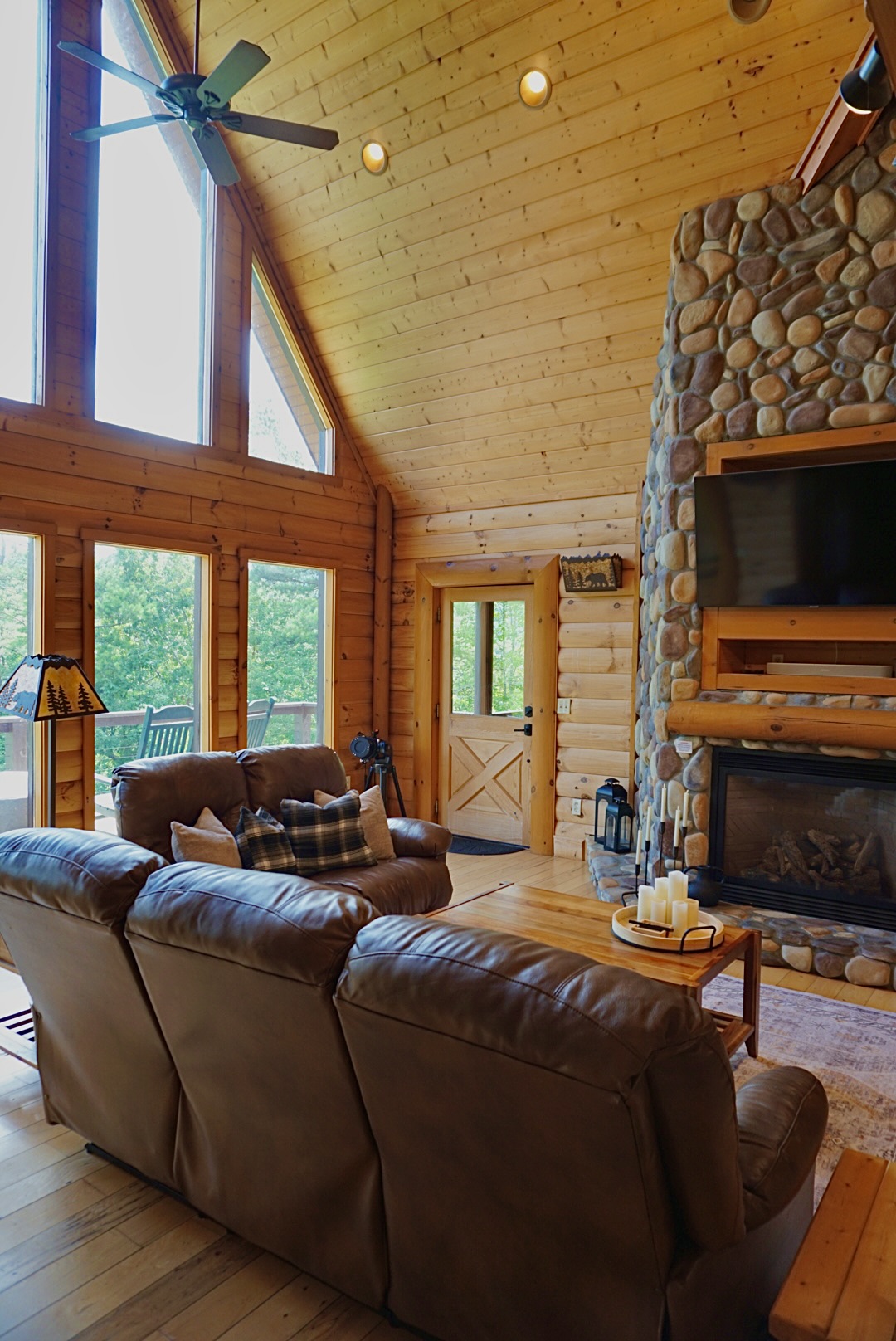 Living Room: Sunlight dances through large windows, highlighting a rustic charm and stunning views!