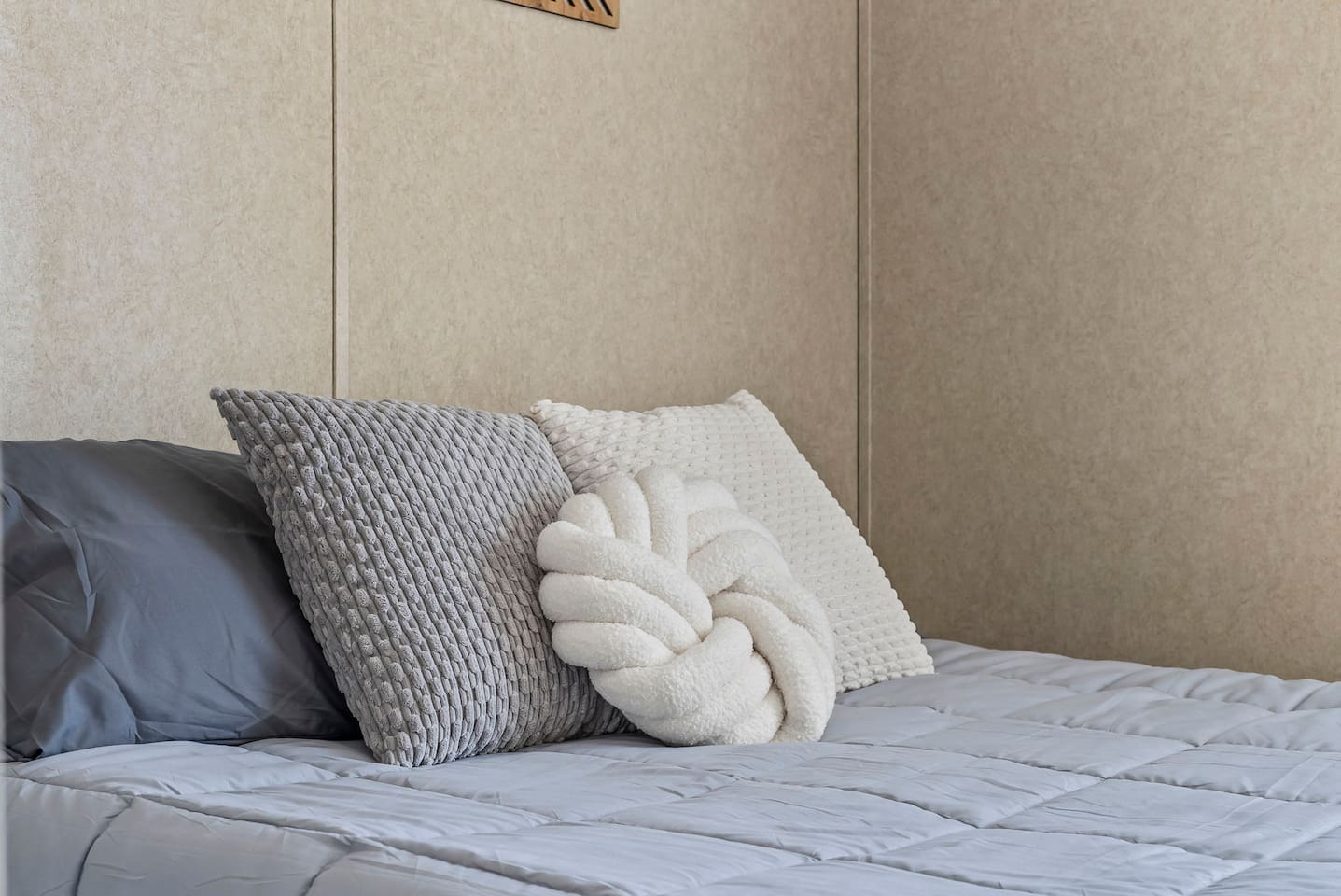 Stylish close-up of the bed with modern accent pillows and soft linens designed for comfort and relaxation.