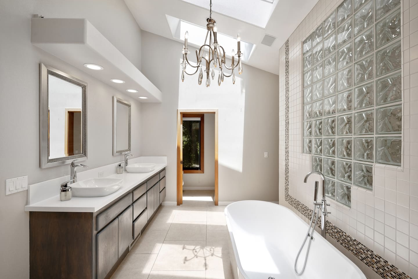Private ensuite primary bathroom has a large standing tub, double-sink vanity, shower, and two walk-in closets.