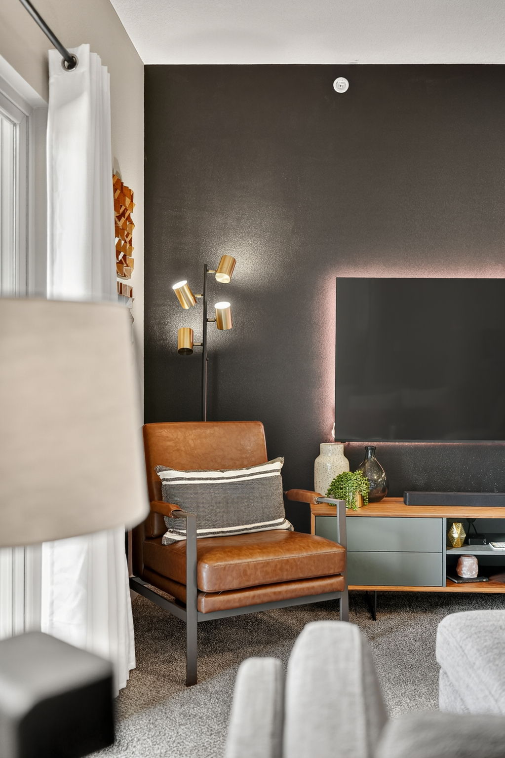 Designer leather armchair and console styling with plants, throws, and curated accessories.