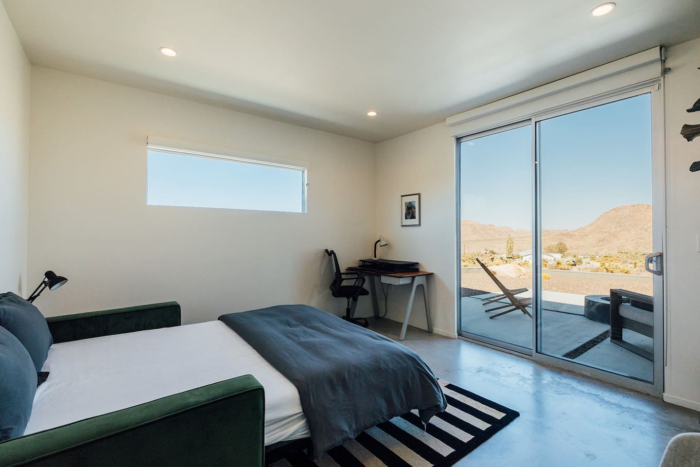 East facing bedroom with dedicated work space with an adjustable sitting/standing desk and direct access to the patio. Perfect for catching the sunrise.