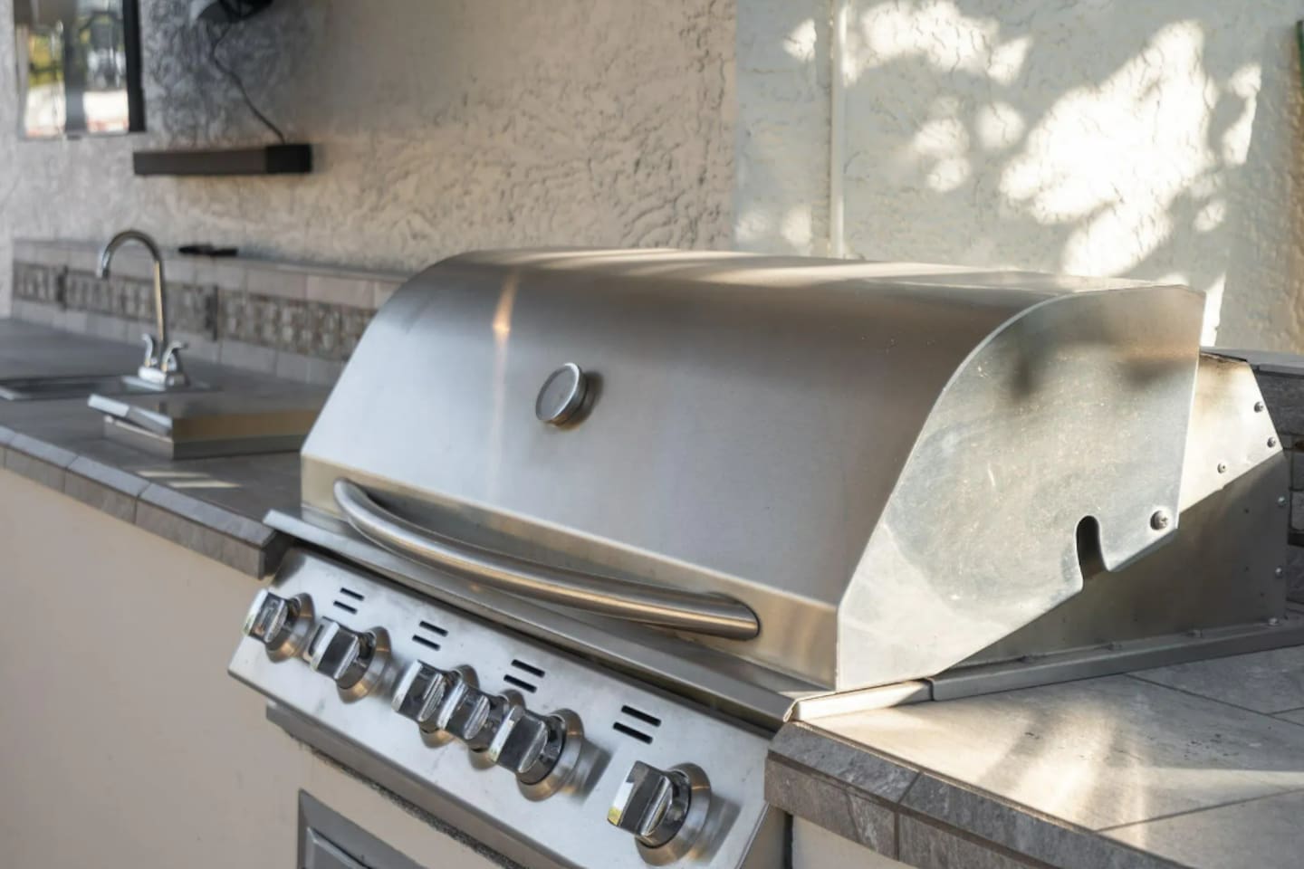 A commercial-grade grill anchors the outdoor kitchen, ready for a group cookout at any hour.