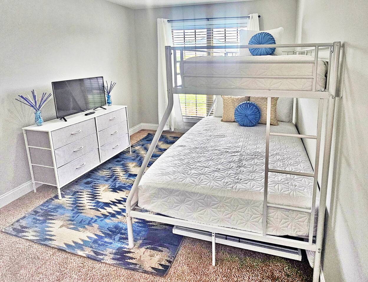 This serene bedroom can sleep up to 4 adults. Full-length mirror and flat screen smart TV in here as well!
Full-size bed and 2 twin beds. 1 twin bed is a trundle located under the bunk. 