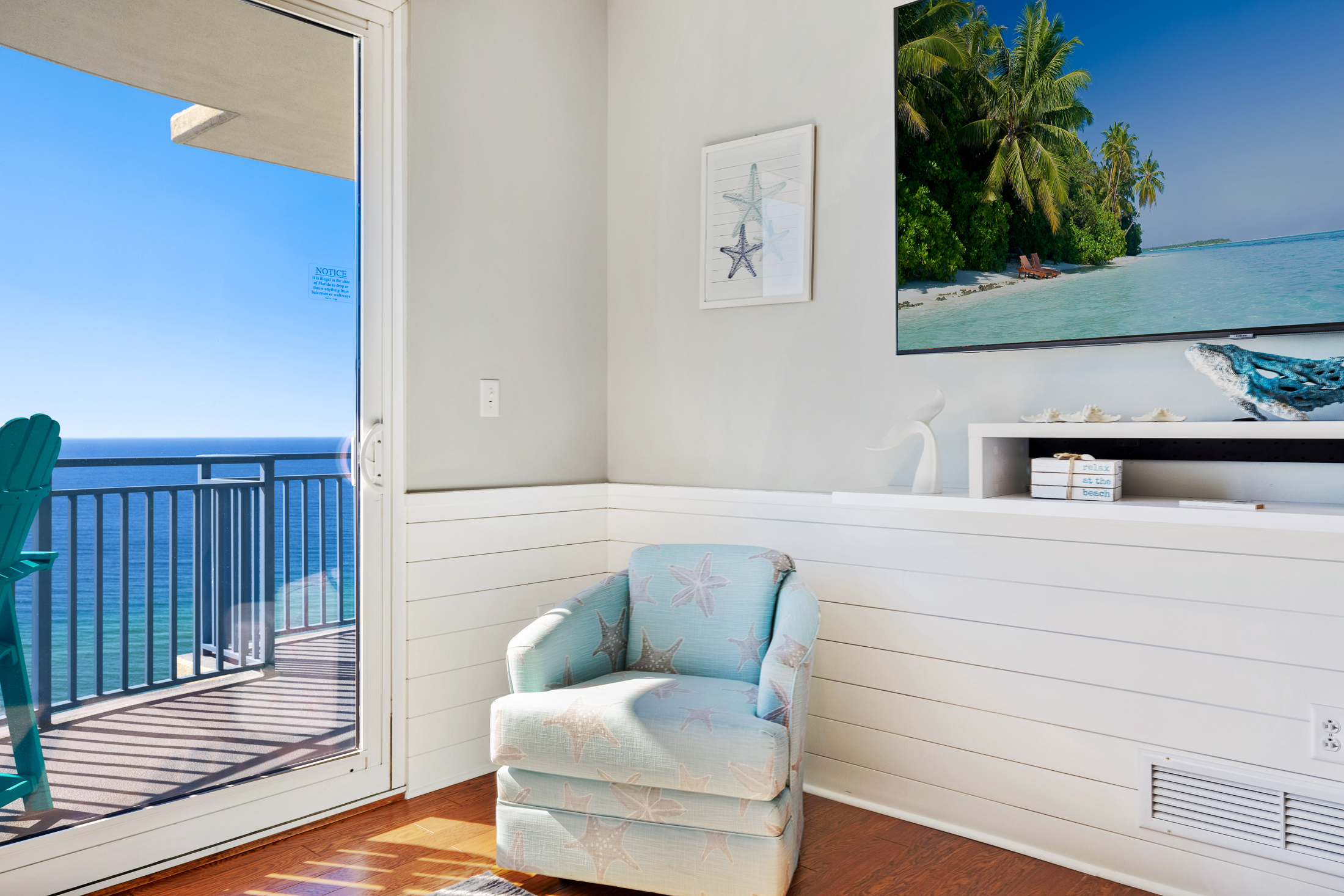 Beach themed swivel captains chairs flanking the TV provide additional living room seating.  And look at the shiplap which begins in the entryway and is carried to the living room.