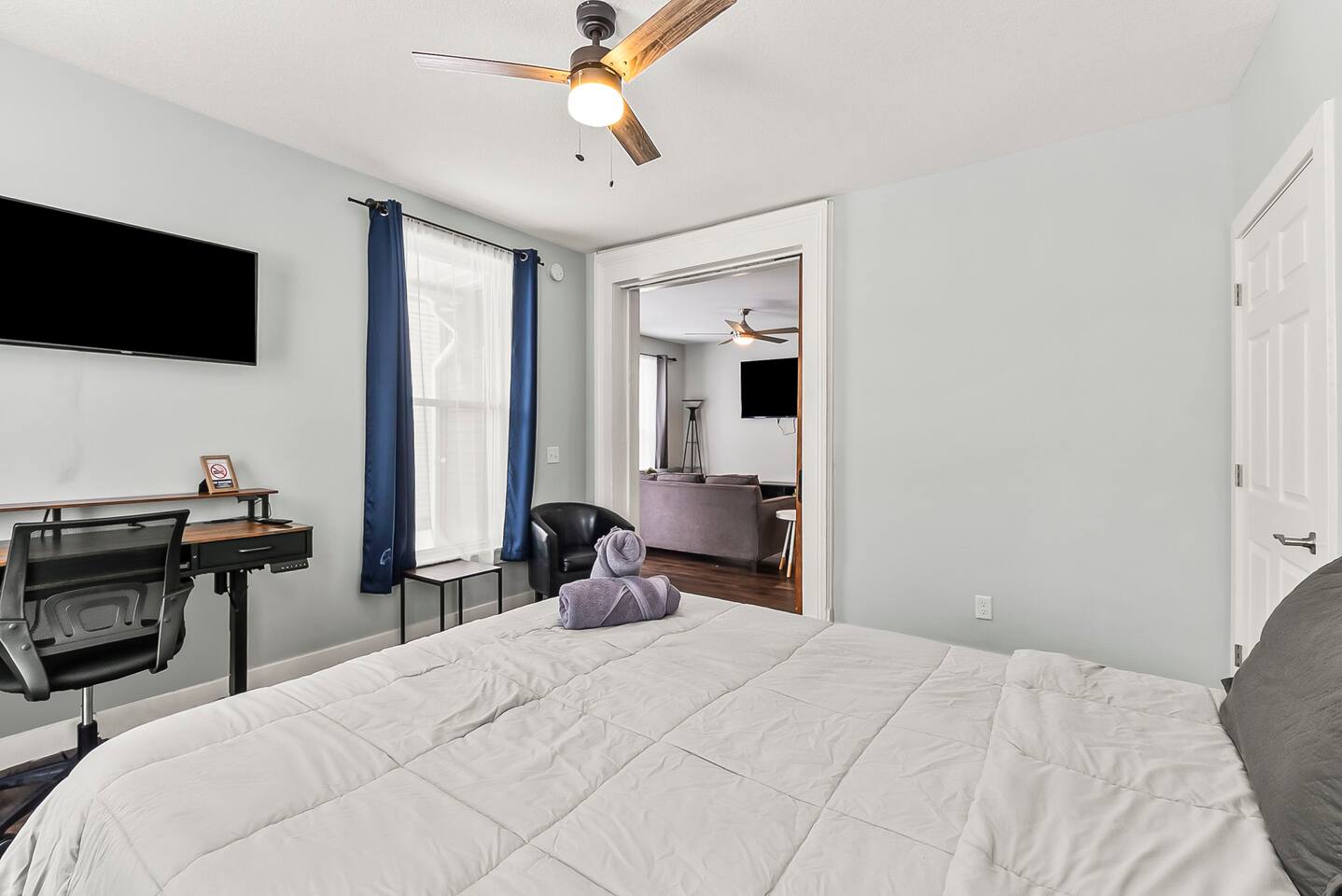 Bedroom workspace setup with desk, chair, wall-mounted TV, and peaceful views—ideal for remote work.