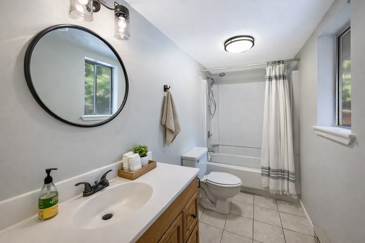 Clean, modern full bath with fresh linens and bright natural light.