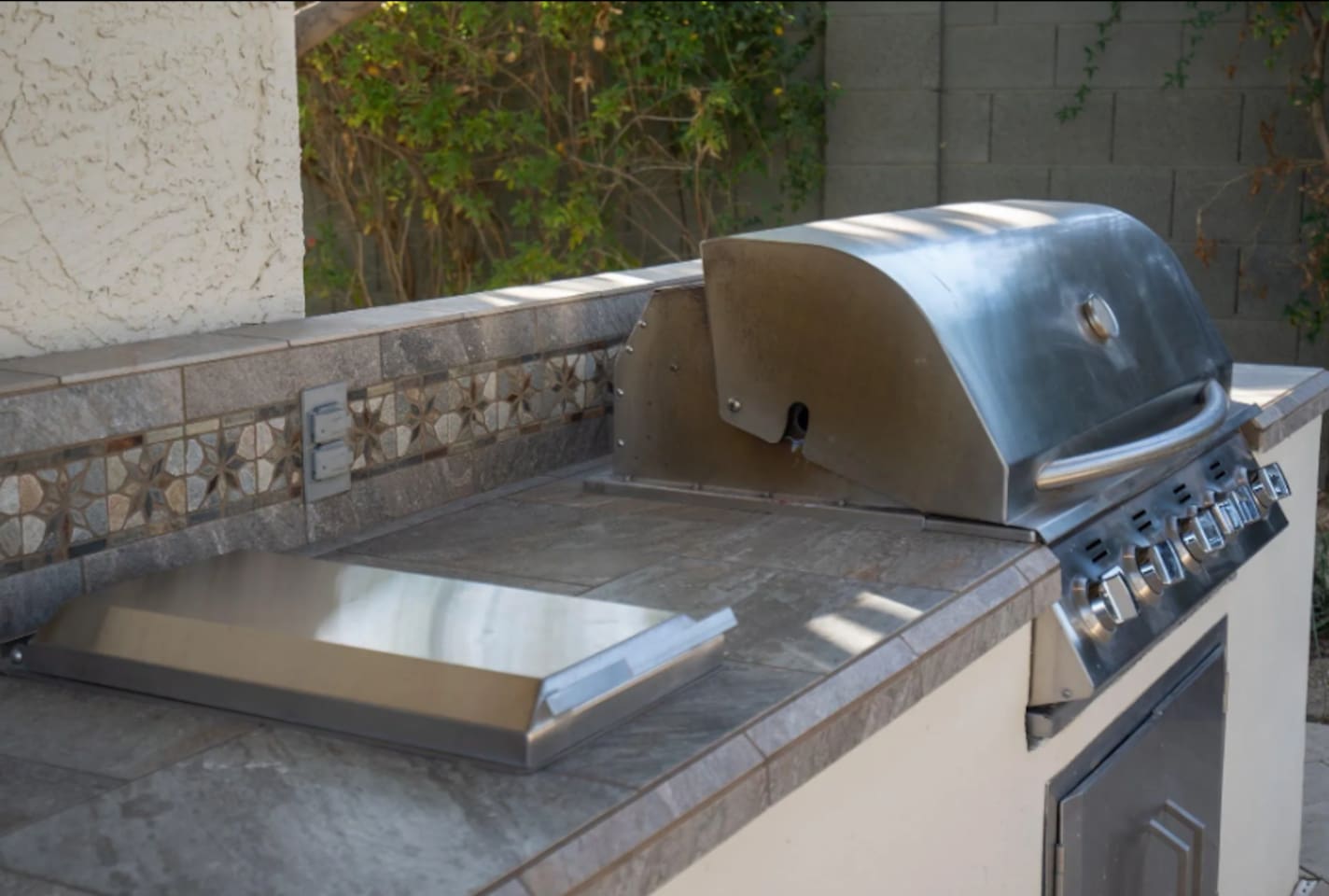 A built-in stainless grill makes outdoor cooking effortless, ready for burgers, steaks, or whatever the group's craving.
