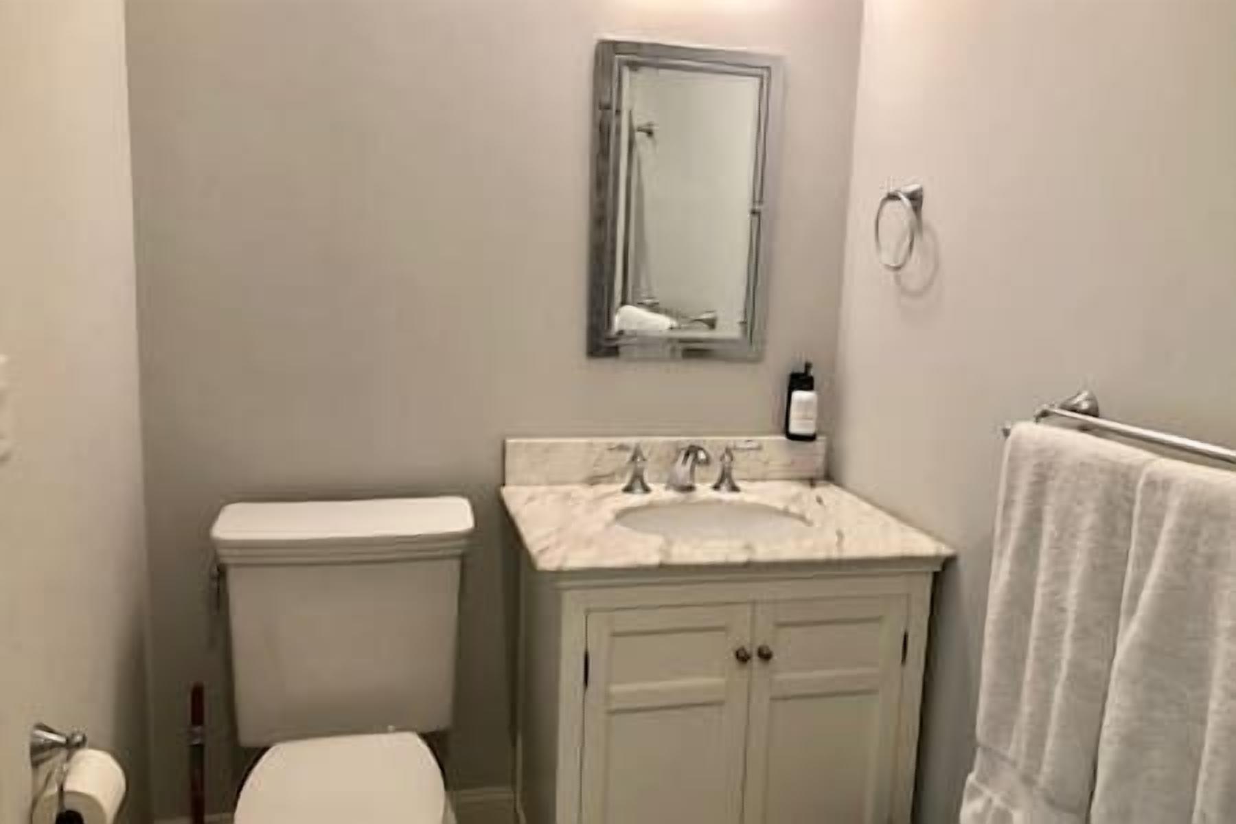 Private ensuite bathroom off the main bedroom with marble-topped vanity, plush towels, and a sleek walk-in shower for a spa-like experience.