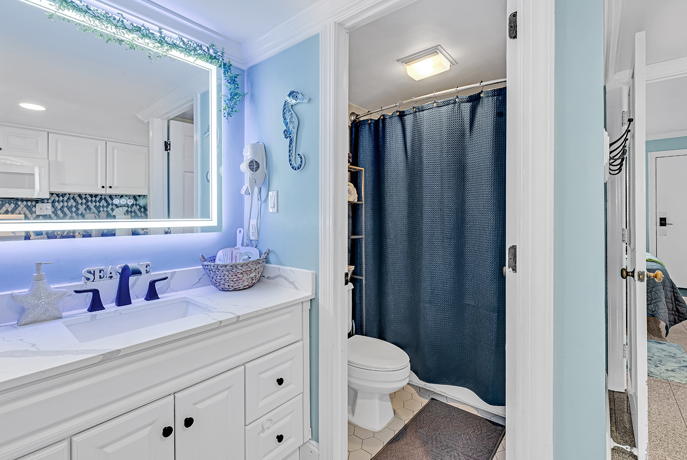 Full bathroom with walk-in shower, LED mirror, and dual sink vanity