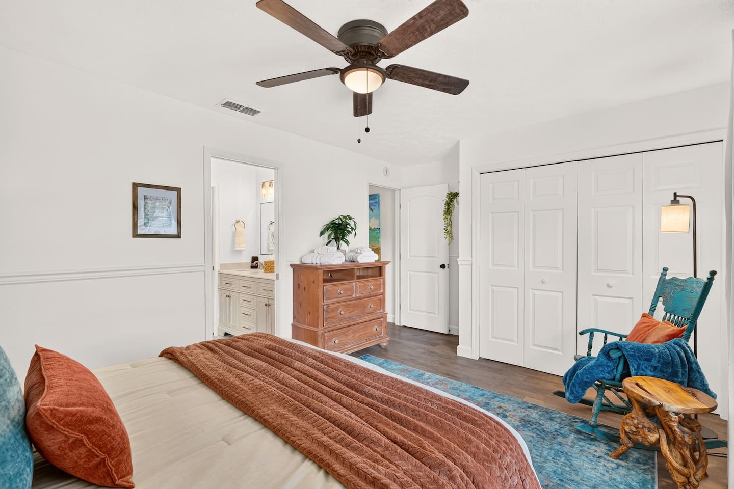 Bedroom 2 features a queen bed, a dresser, and rocking chair.