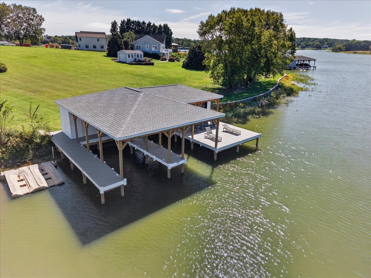 Private boathouse with multiple covered slips and an oversized deck extending over the water.