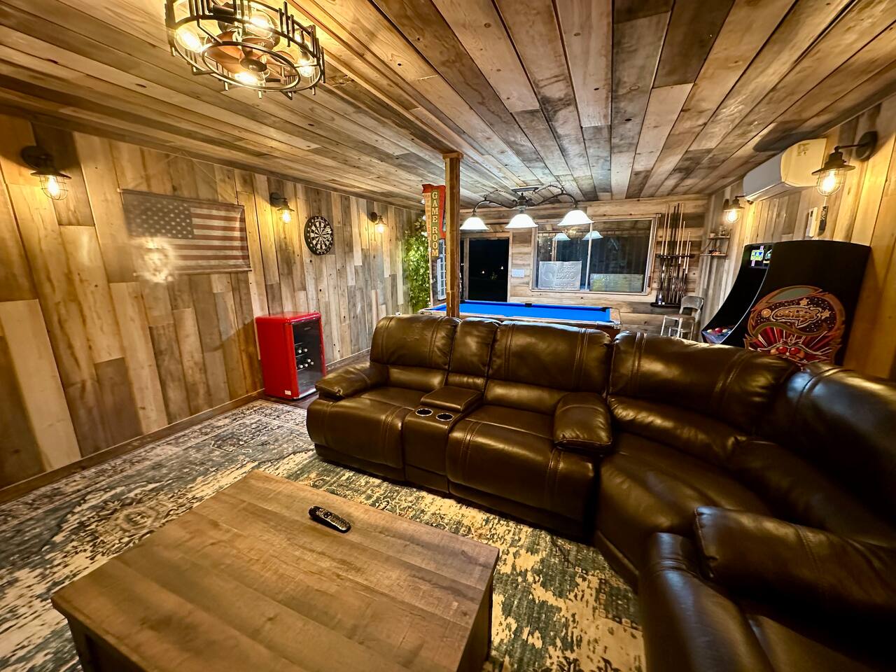 Seating area in game room, darts, mini fridge