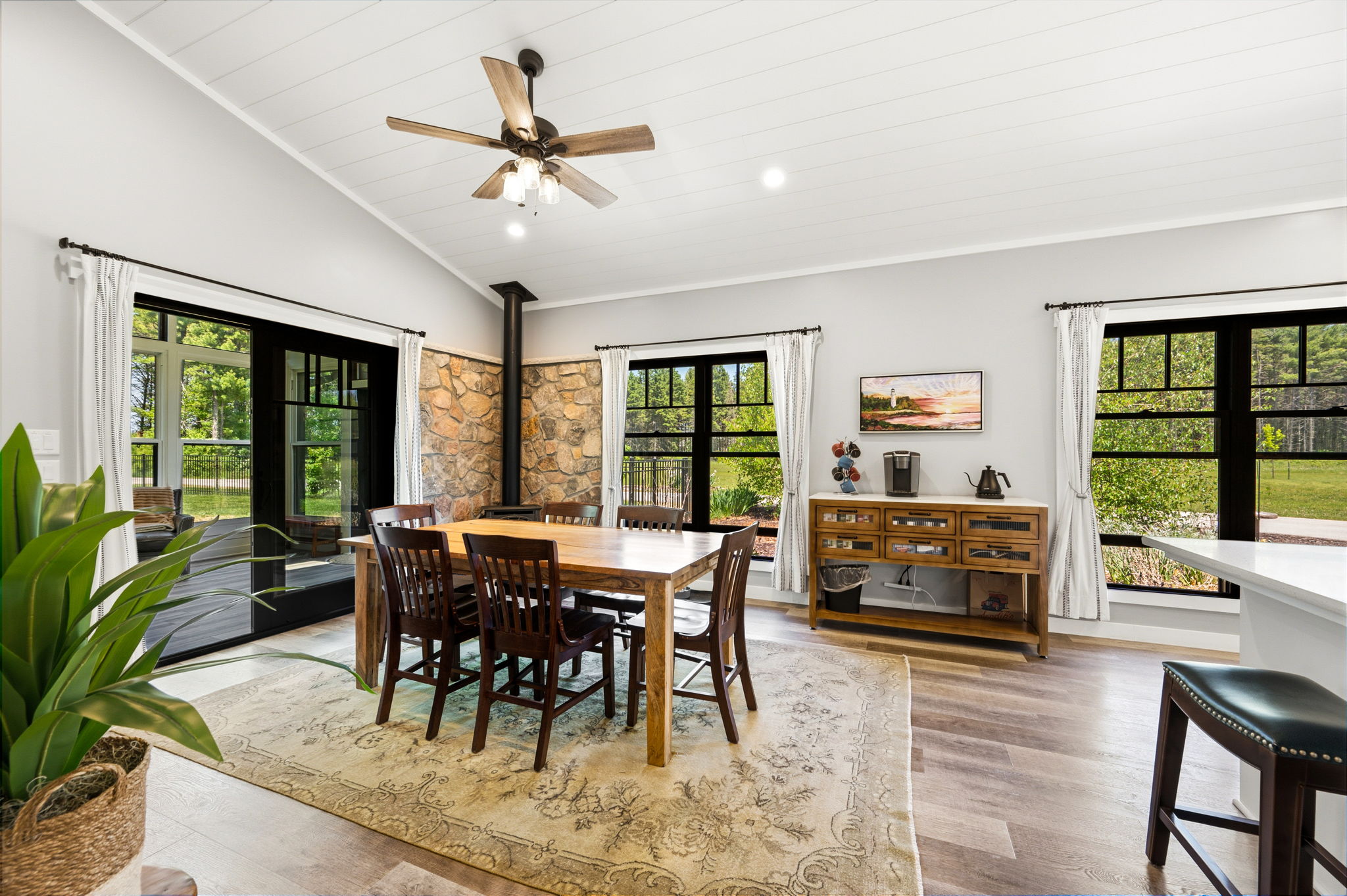 Enjoy family dinners at the solid-wood dining table, warmed by a cozy propane fireplace set against a dramatic floor-to-ceiling stone wall.