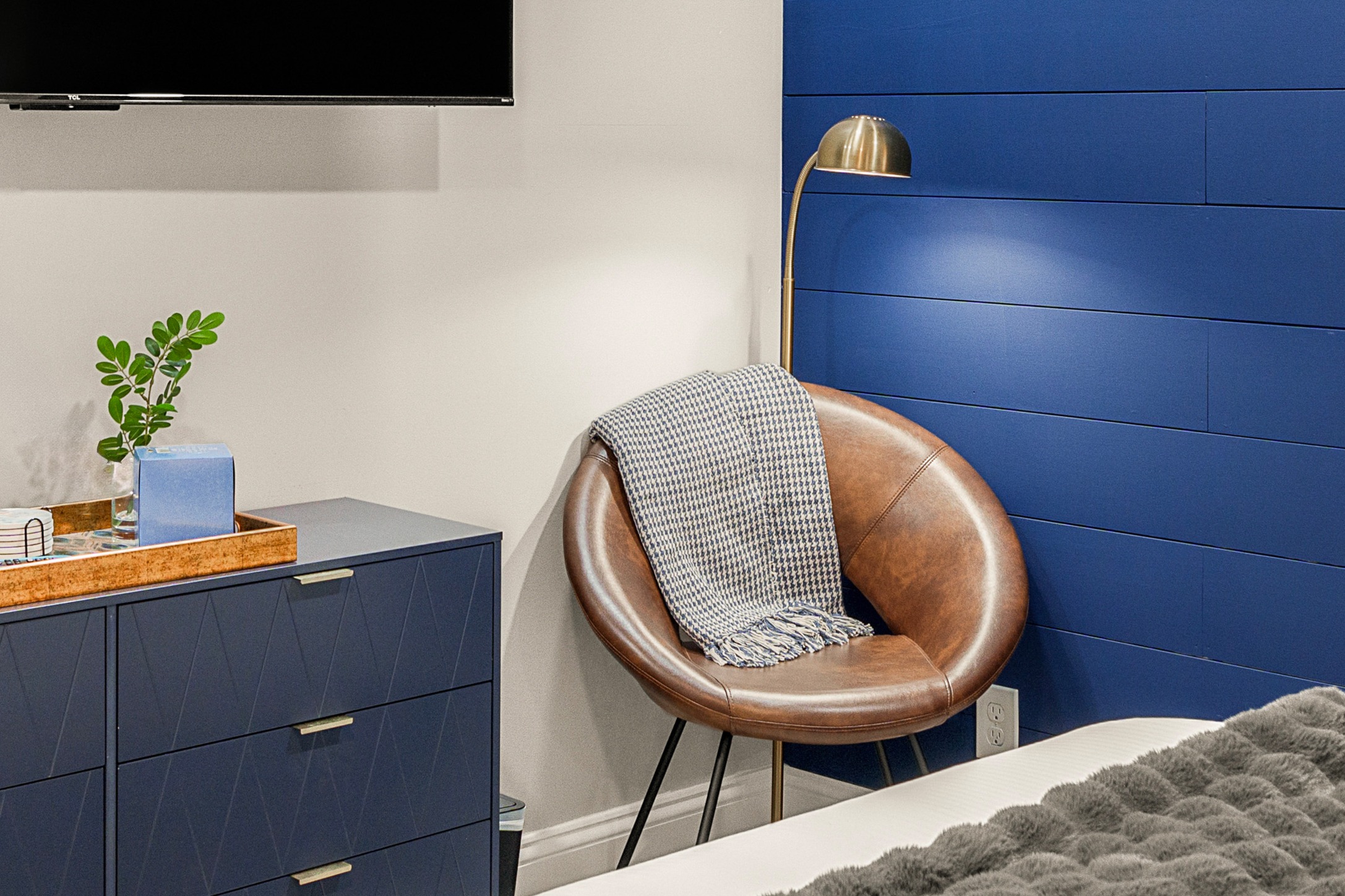 Chic lower-level bedroom with bold color, designer accents & cozy textures
