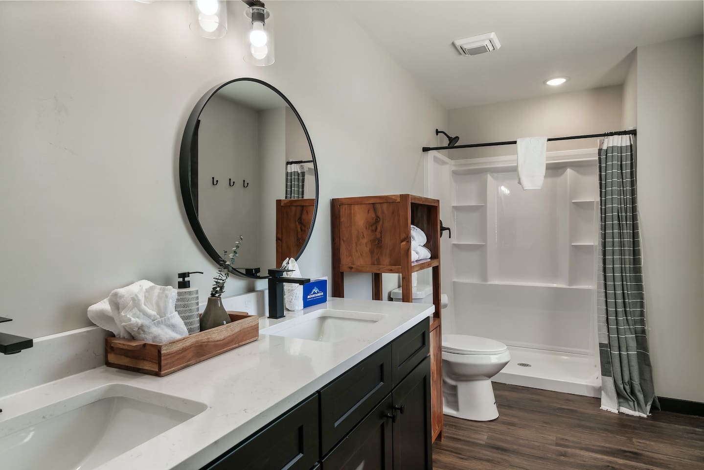 Main-floor full bathroom with double vanity and modern walk-in shower.