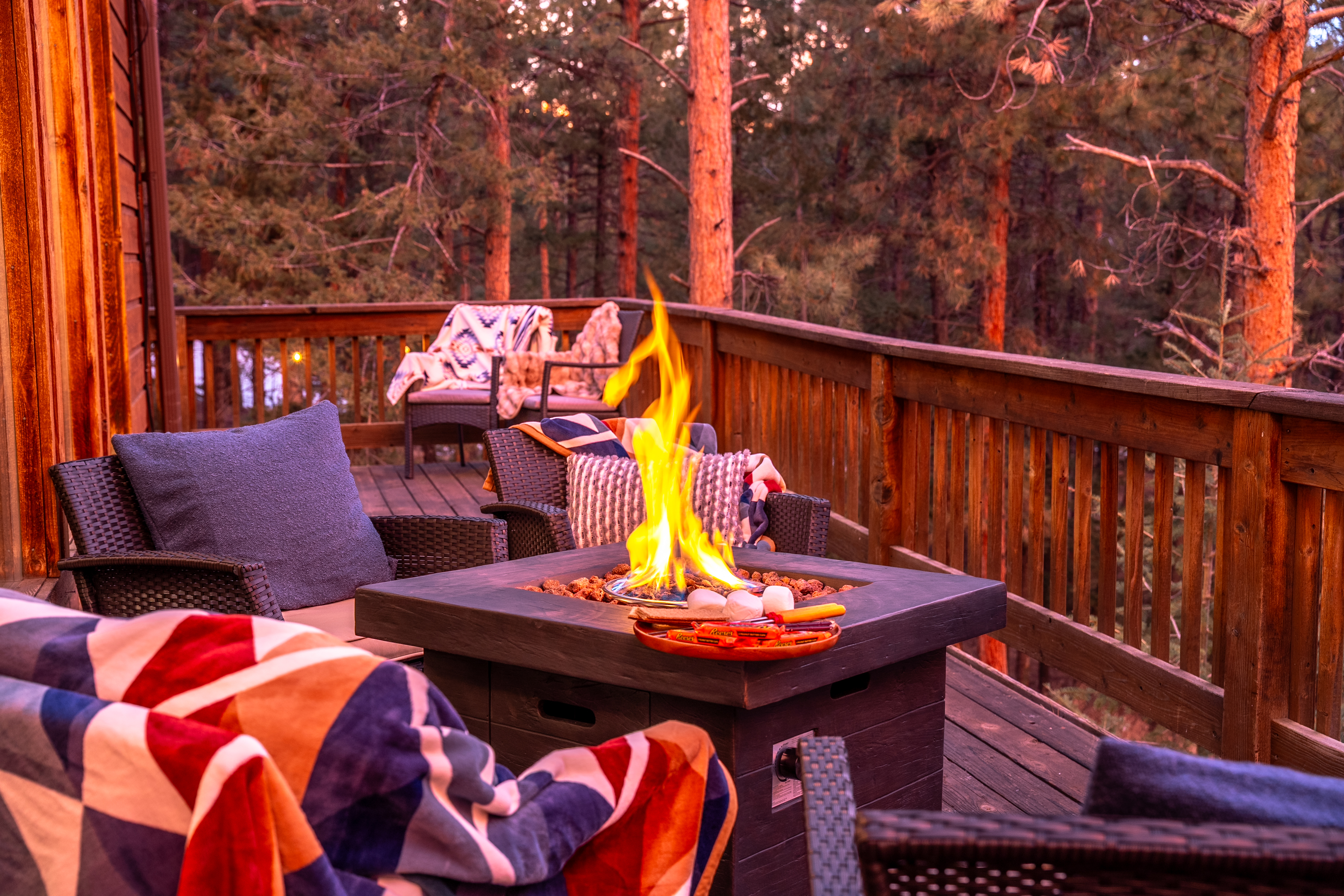 🔥🪵 Cozy deck nights—kick back with blankets, comfy seating, and a glowing fire table ready for s’mores and stories under the pines 🌲✨