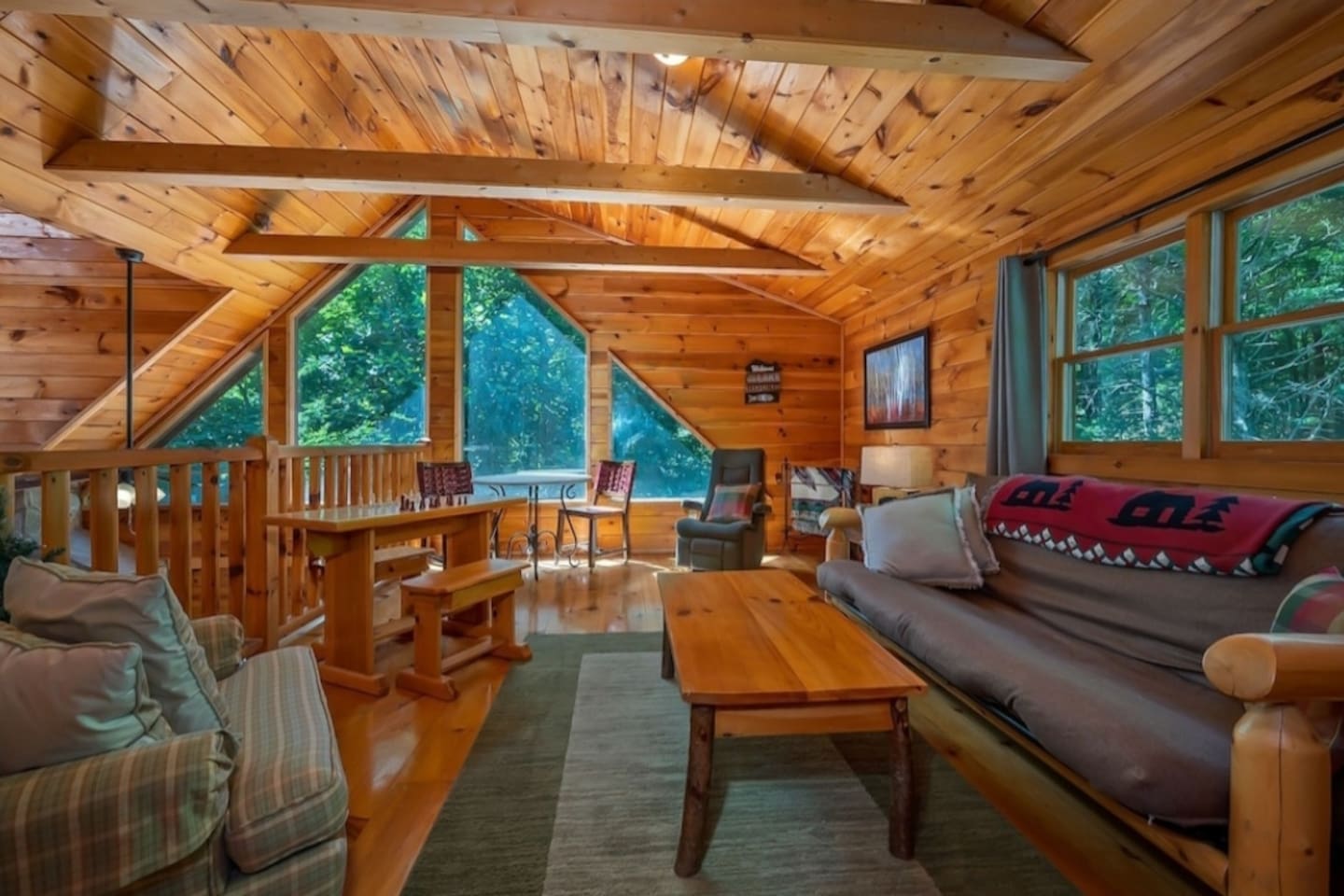 Upstairs loft area with queen futon sleeper, sitting area and  flat screen tv.