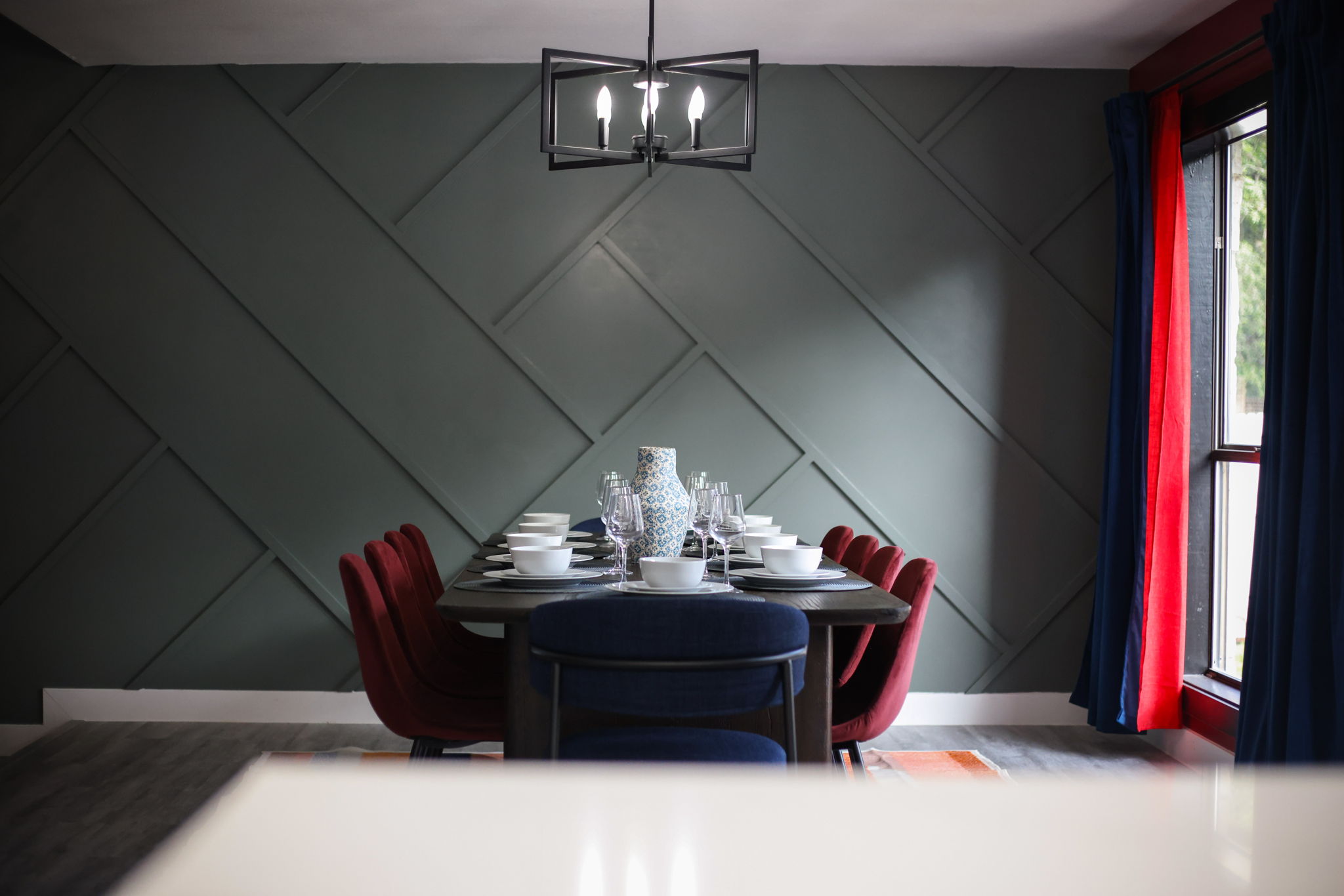 Dining Area: Natural wood tones pair beautifully with the geometric accent wall.