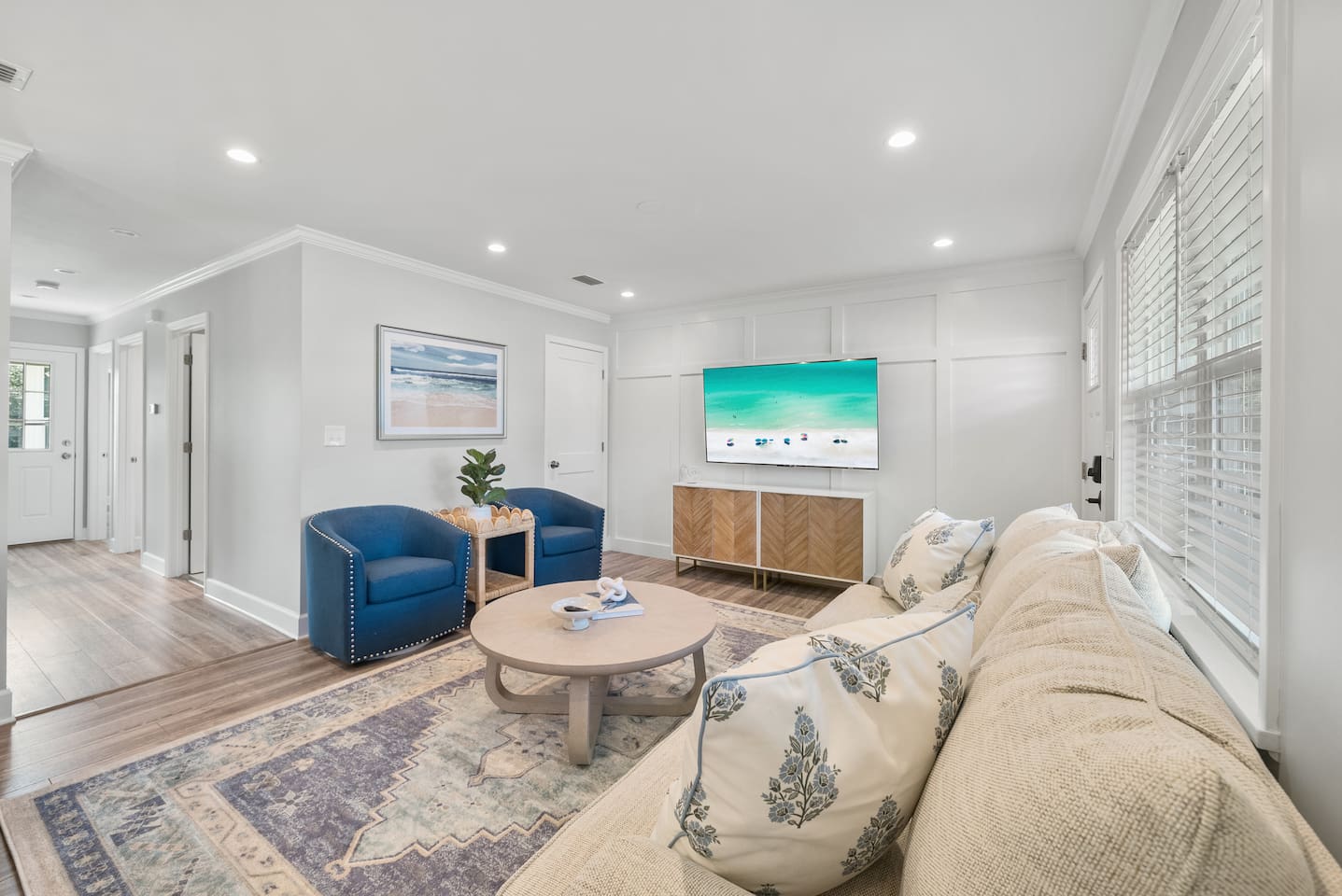 Living room of Unit A. Featuring a sleeper sofa, open concept to the kitchen and a smart TV.