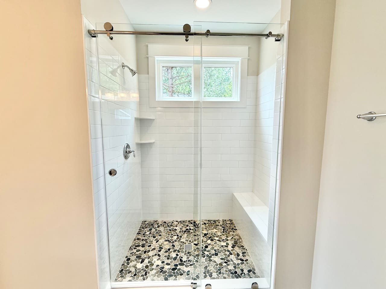 Guests will love the large shower with sliding glass barn style doors, pebble floors and the natural light that comes in from the windows!