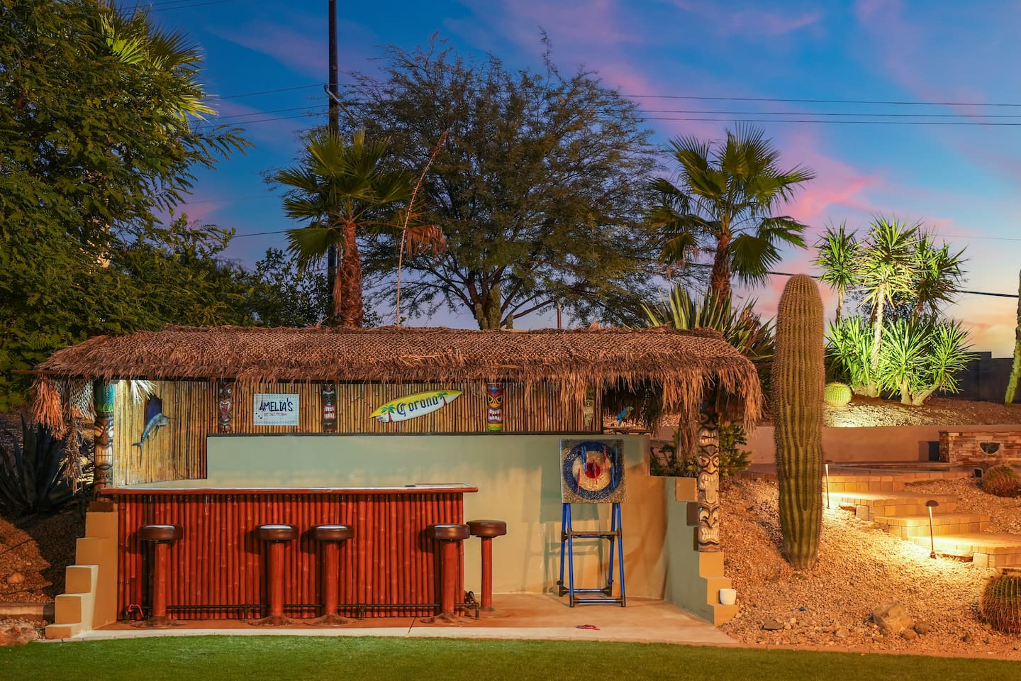 Tiki-style outdoor bar with bar seating, creating the perfect space for evening drinks and entertaining.