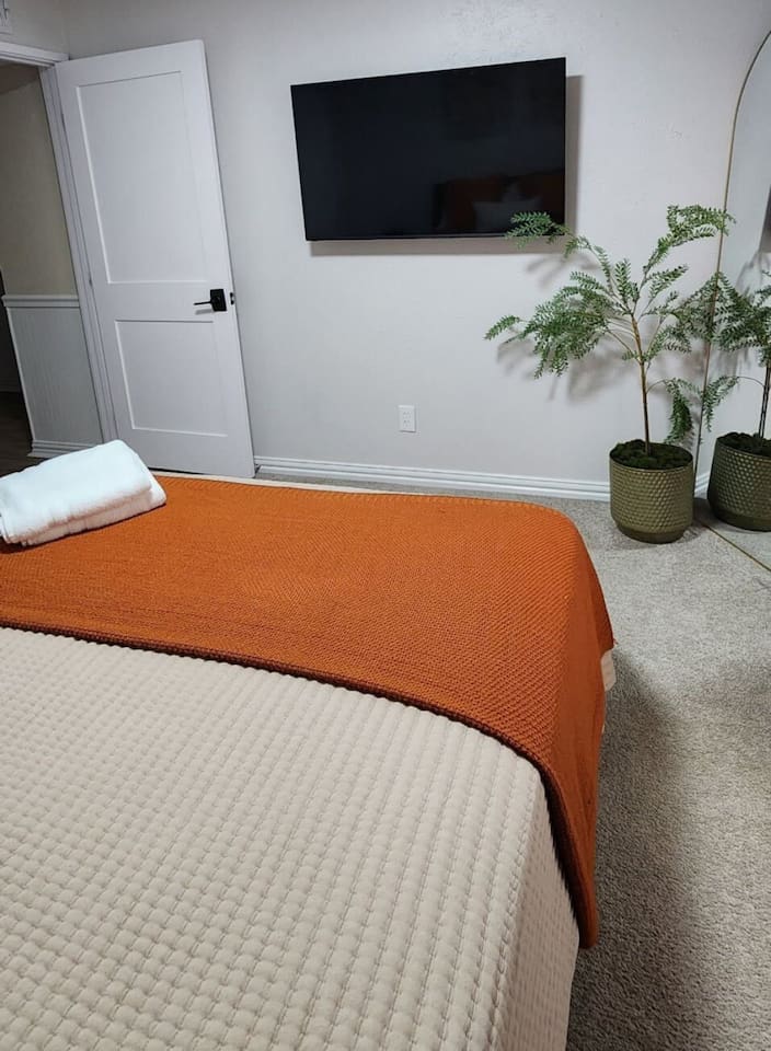 Relax in this thoughtfully designed queen bedroom featuring a plush queen mattress, Smart TV with streaming services, blackout curtains, and a ceiling fan for year-round comfort. Enjoy fast Wi-Fi, bedside charging outlets, and soft hotel-quality line