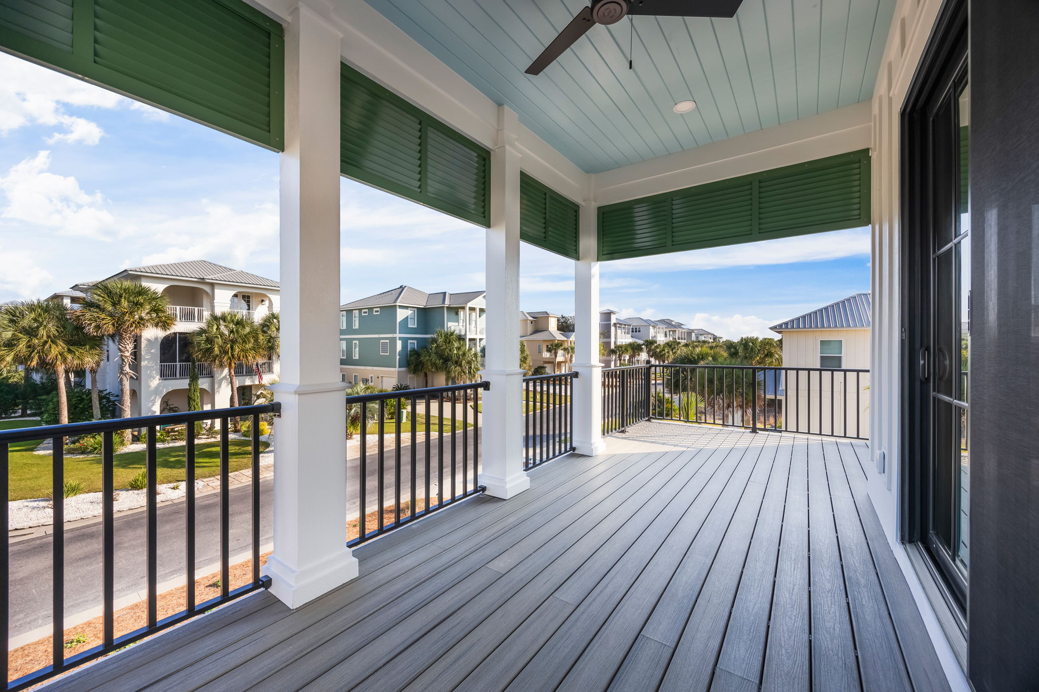 Covered upper front porch just off the upstairs master and hallway beverage station with coffee, tea, and a mini fridge for cold drinks—no need to head downstairs. Adirondack seating, classic haint blue ceiling, and peaceful neighborhood views create a re