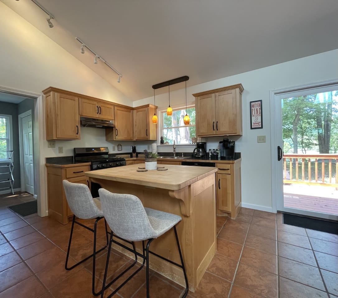Modern appliances and breakfast island make food prep a charm in the light filled kitchen.