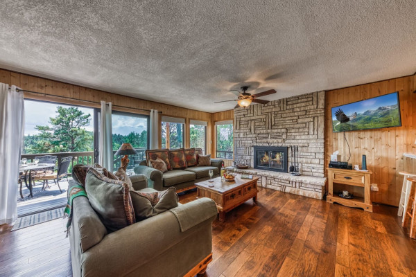Unwind in the expansive living room, featuring a warm fireplace and breathtaking views of nature — the ideal space for relaxation and tranquility!