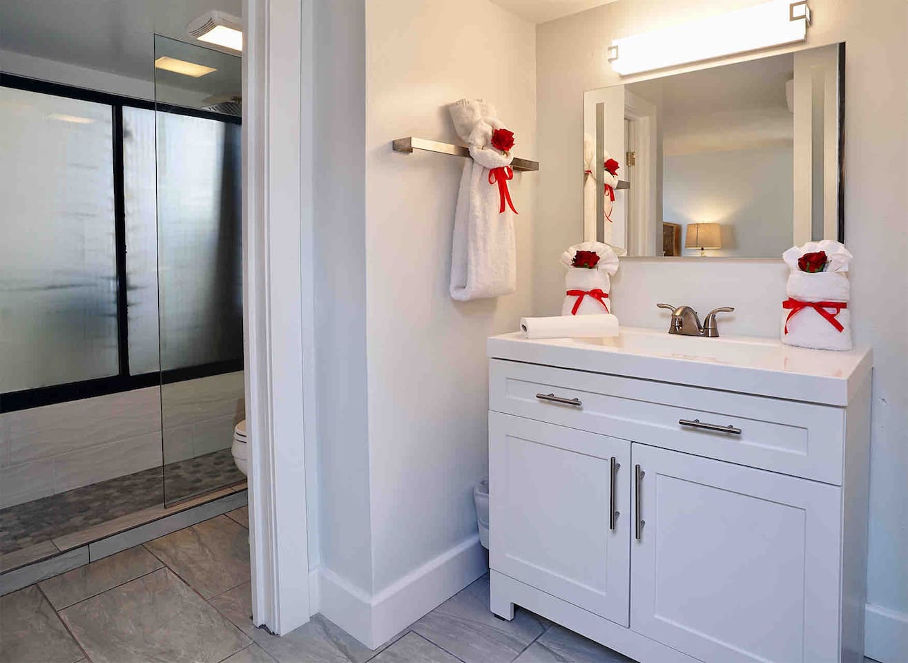 Clean linens and large mirror in the separate sink area