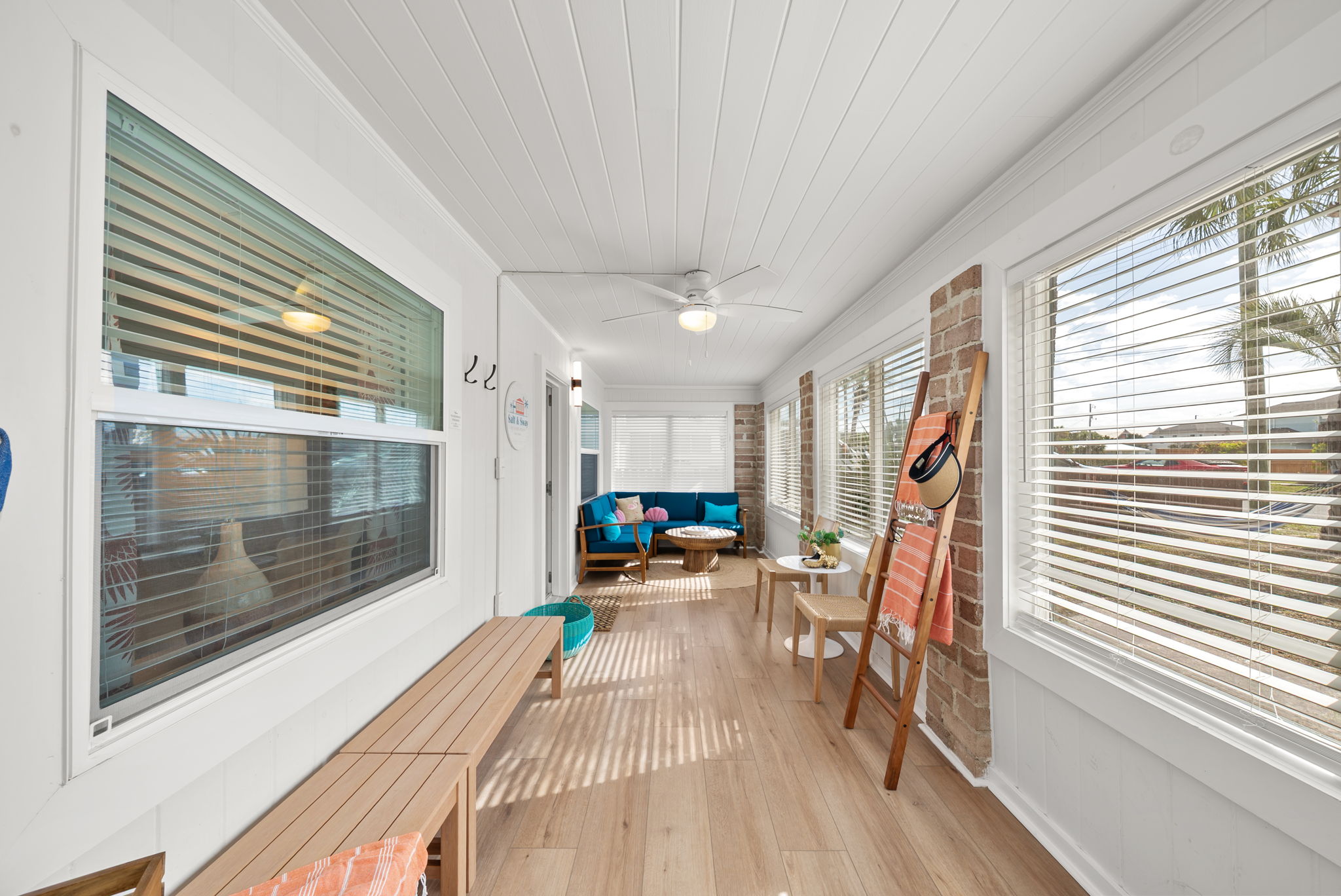 Step into the bright sunroom corridor on arrival, shiplap ceiling, a
bench to drop your bags, a ladder towel rack stocked for the beach, and natural light that sets a vacation tone immediately.