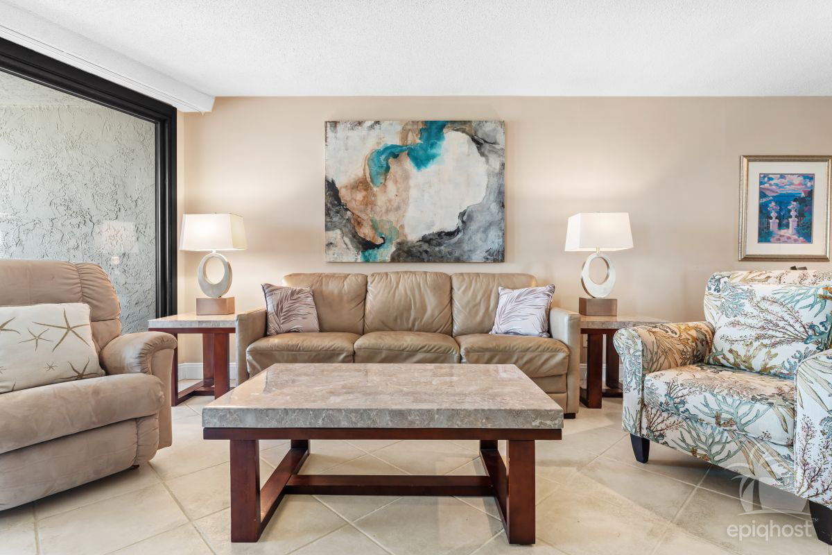 Living room with large HDTV, sleeper sofa, and sliding doors to balcony