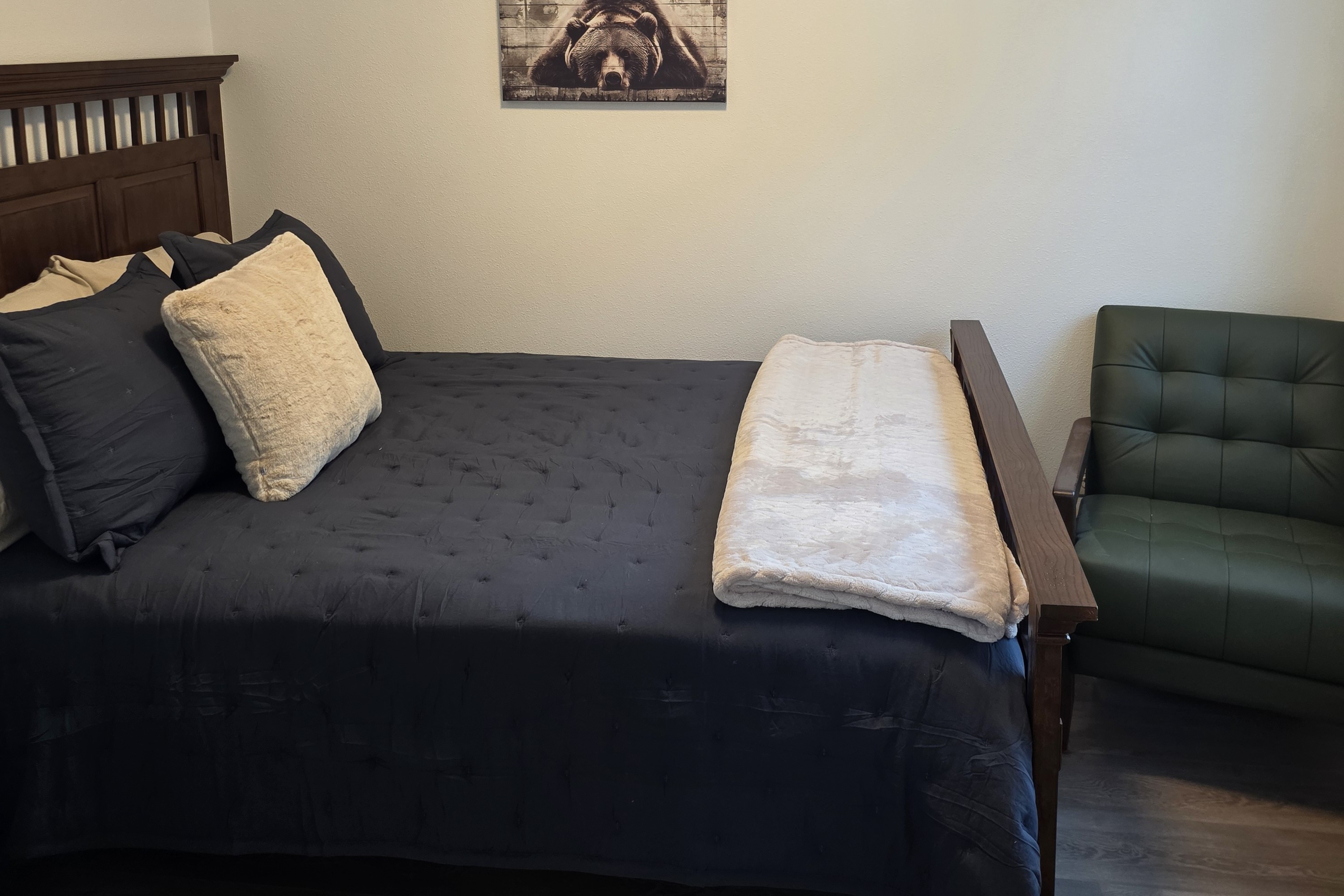 Bedroom on main floor includes a Queen Size Bed with night stand, closet space, chair and TV.