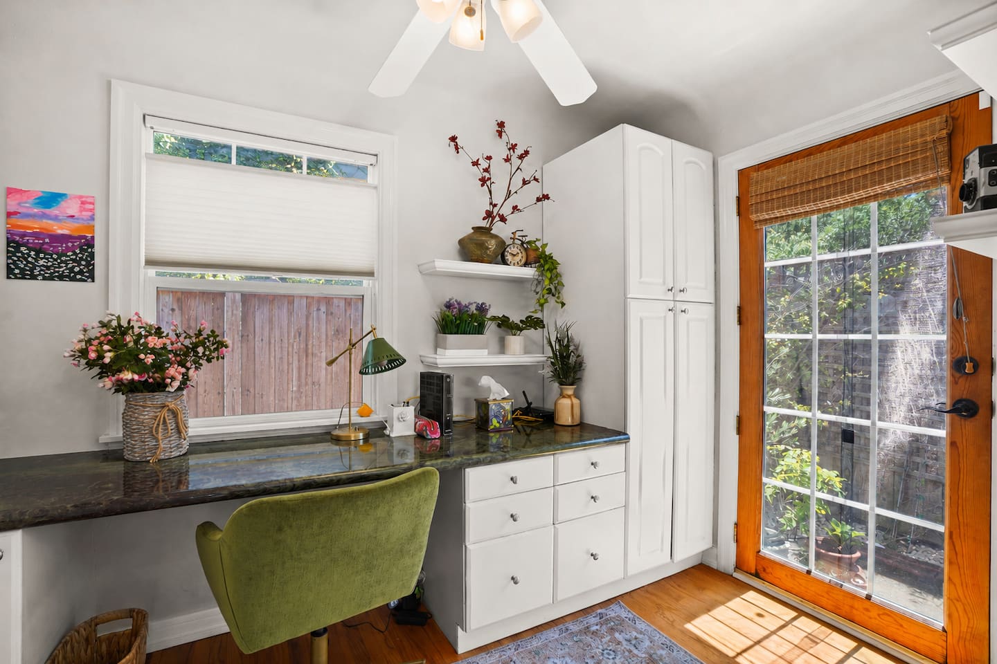 Dedicated workspace that opens to the backyard, with a serving board and cheese cutter available in the cabinet.